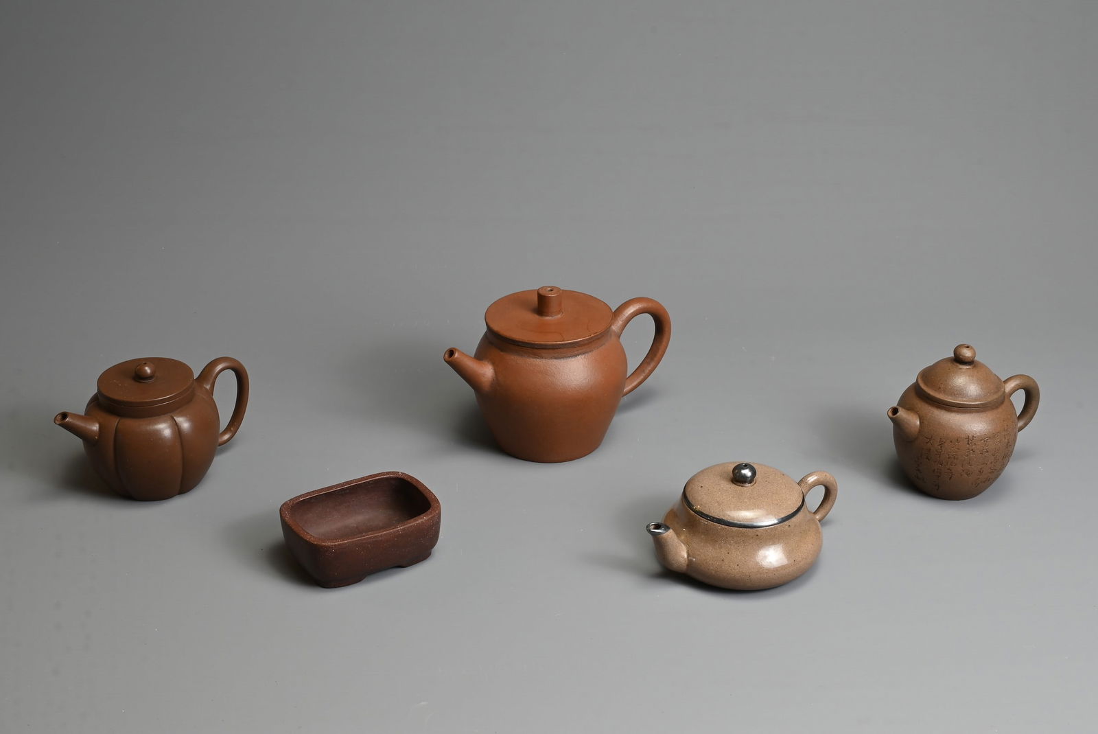 A GROUP OF CHINESE YIXING POTTERY, 20TH CENTURY. To include four teapots of varying forms each (1 of 6)