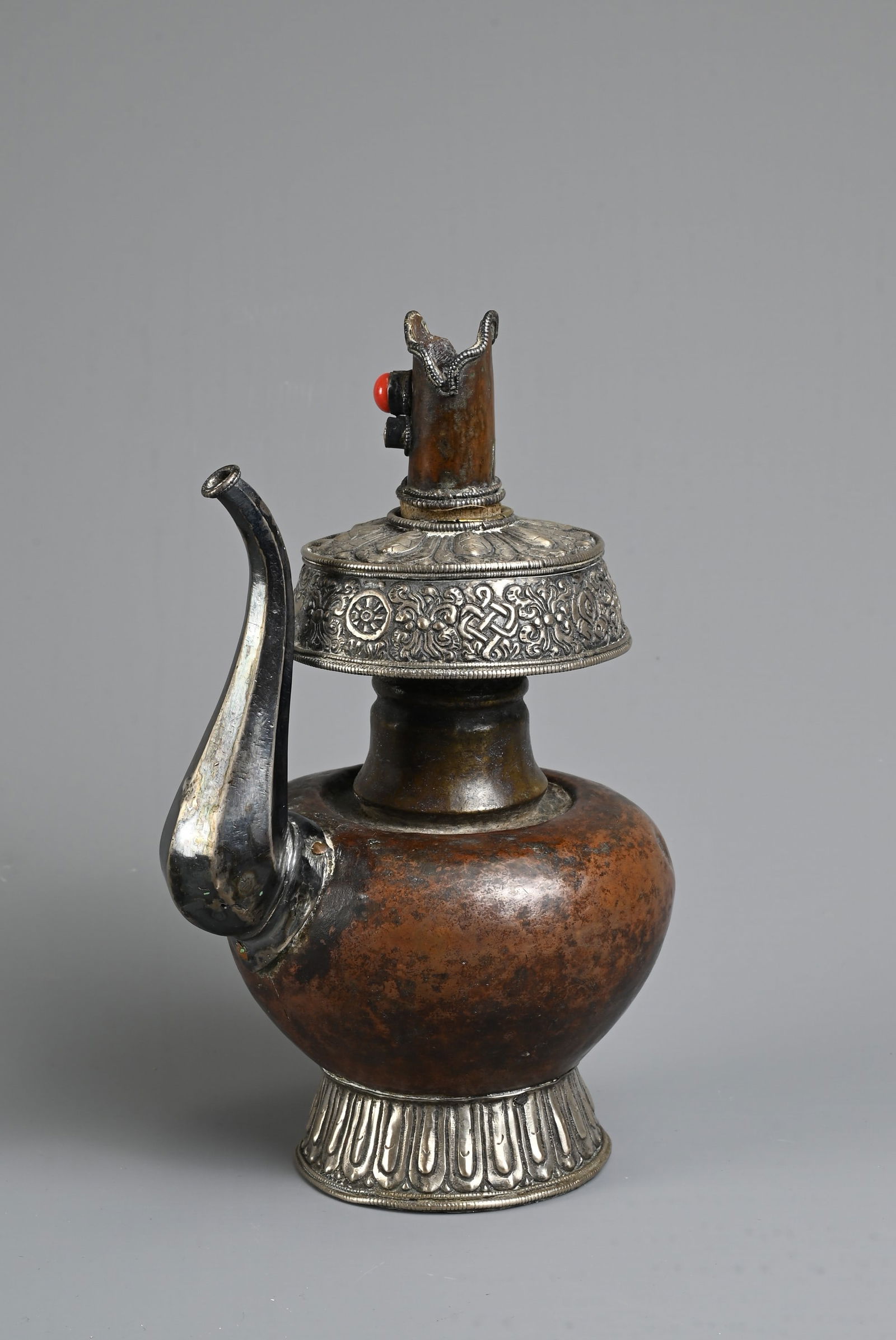 A TIBETAN COPPER AND SILVER EWER, BUMPA, 19/20TH CENTURY. With copper body and splayed silver foot (1 of 7)