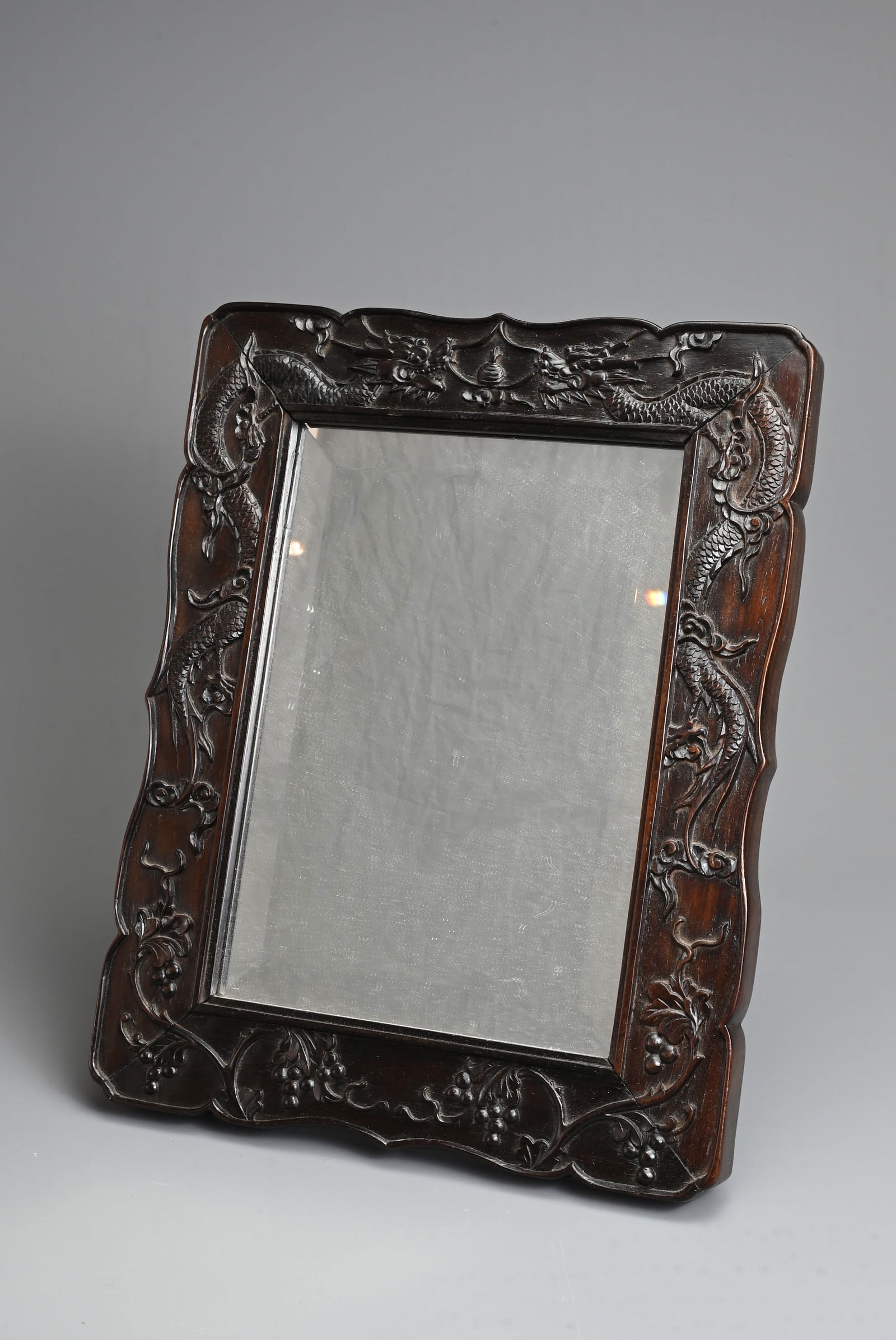 A CHINESE CARVED HARDWOOD FRAMED MIRROR, EARLY 20TH CENTURY. Decorated in relief with dragons and (1 of 4)