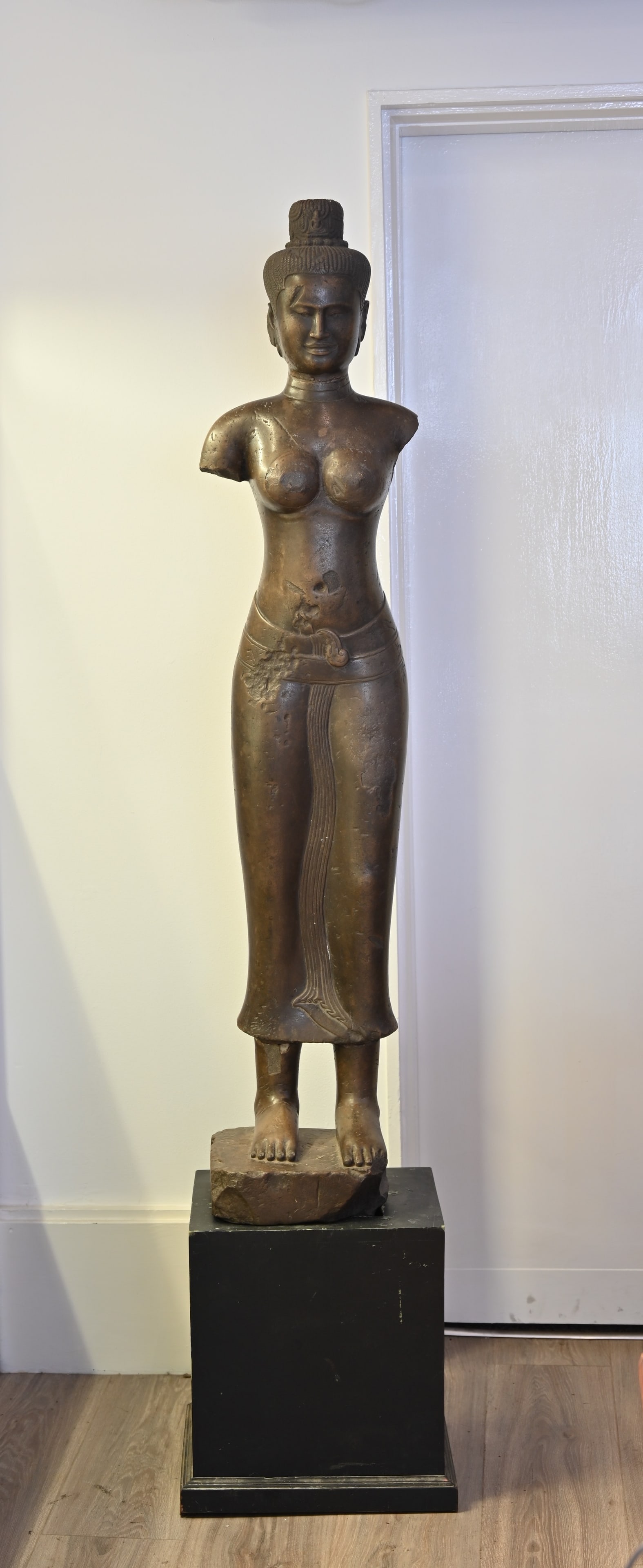 A VERY LARGE AND HEAVY CARVED GREY STONE FIGURE OF FEMALE DEITY, KHMER BAPHUON STYLE. Fitted onto a (1 of 8)