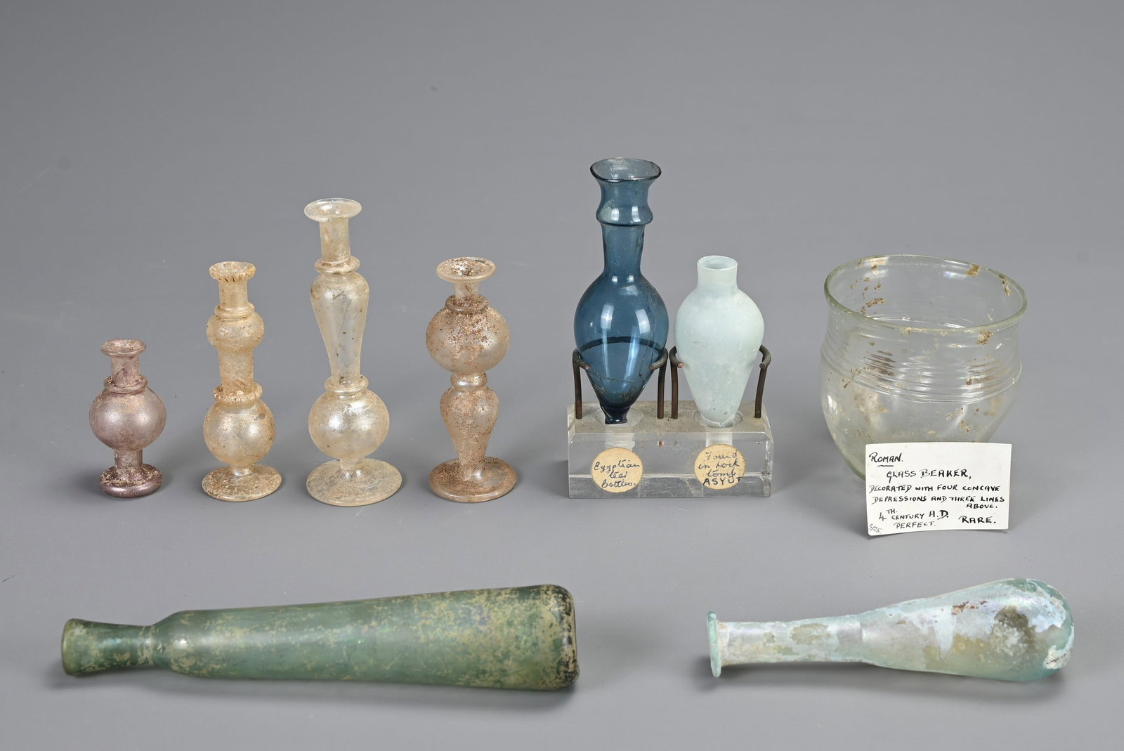 A GROUP OF ROMAN GLASSWARE ITEMS, CIRCA 1-5 CENTURY AD. Of various forms to include a clear glass (1 of 3)