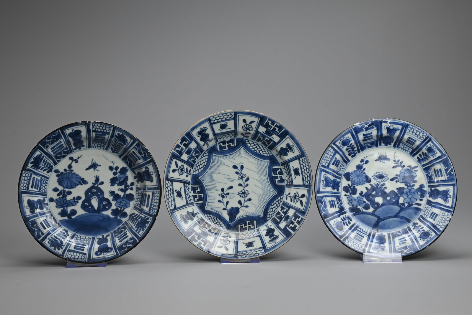 THREE CHINESE BLUE AND WHITE KRAAK STYLE PORCELAIN DISHES, 17/18TH CENTURY. To include a pair: THREE CHINESE BLUE AND WHITE KRAAK STYLE PORCELAIN DISHES, 17/18TH CENTURY. To include a pair decorated with insect and floral scenes surrounded by panels of Buddhist swastika and floral sprays each w