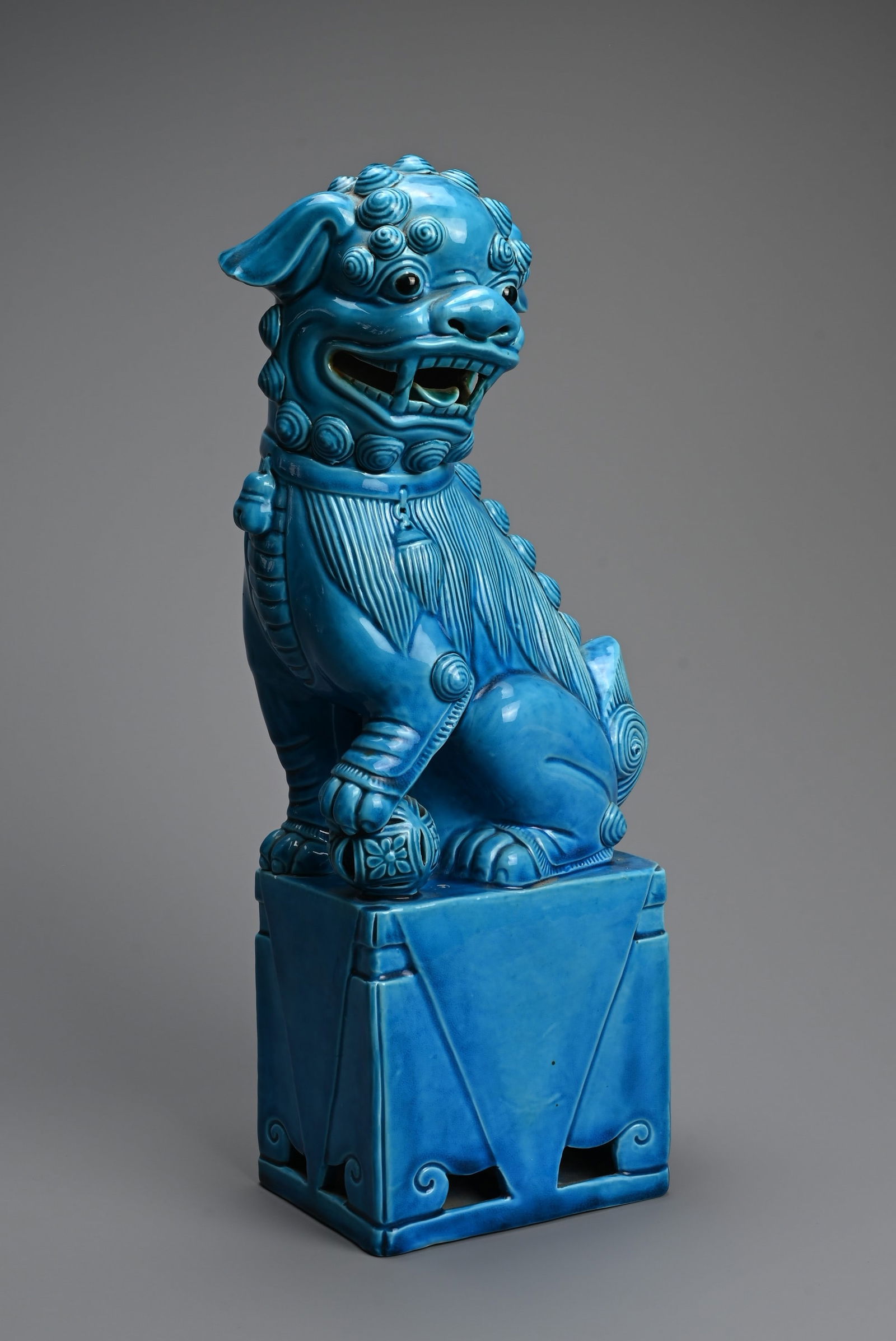 A LARGE CHINESE TURQUOISE GLAZED PORCELAIN FOO DOG, 20TH CENTURY. Seated on a square form stand with (1 of 6)