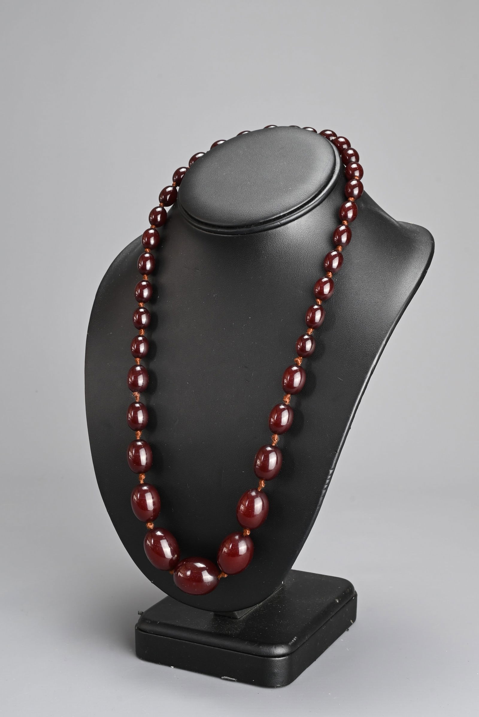 A SINGLE STRAND CHERRY AMBER BEADED NECKLACE. With 36 graduating beads, strung and knotted (no (1 of 6)