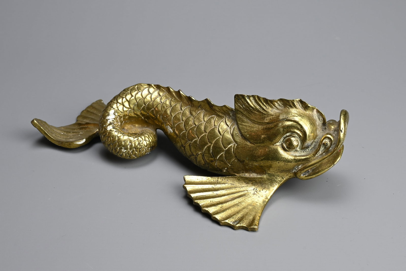 A POLISHED BRONZE MODEL OF A CARP, 19/20TH CENTURY. Heavily cast possibly from a fountain with a: A POLISHED BRONZE MODEL OF A CARP, 19/20TH CENTURY. Heavily cast possibly from a fountain with a small spout in the mouth. 22cm length.