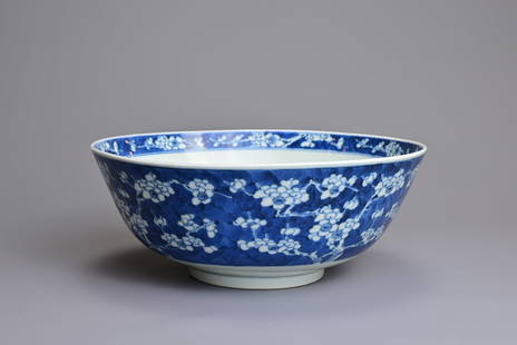A CHINESE BLUE AND WHITE PORCELAIN PRUNUS BOWL, 18TH CENTURY. Well potted decorated with flowering: A CHINESE BLUE AND WHITE PORCELAIN PRUNUS BOWL, 18TH CENTURY. Well potted decorated with flowering cherry blossoms. The base with four character mark of Kangxi in double ring to base. 23.3cm diam. Pro