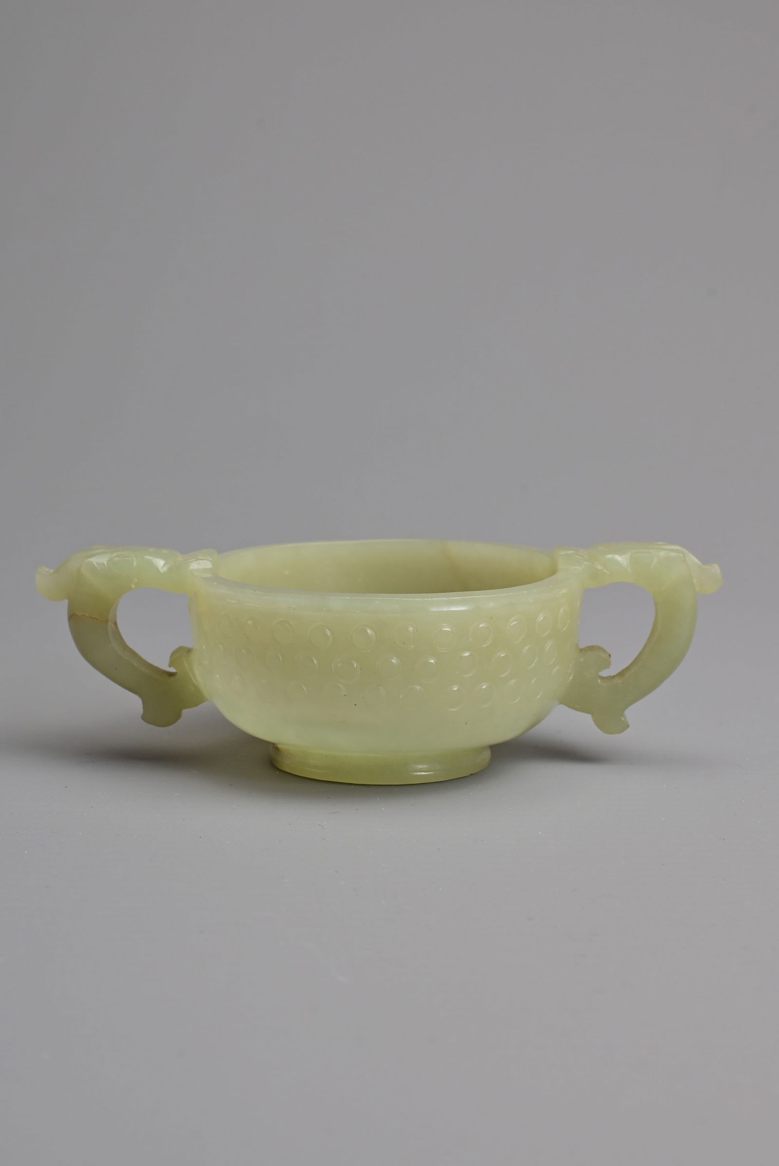 A CHINESE PALE CELADON JADE TWIN HANDLED CUP, MING / QING DYNASTY. Archaistic form with rolled rim (1 of 8)