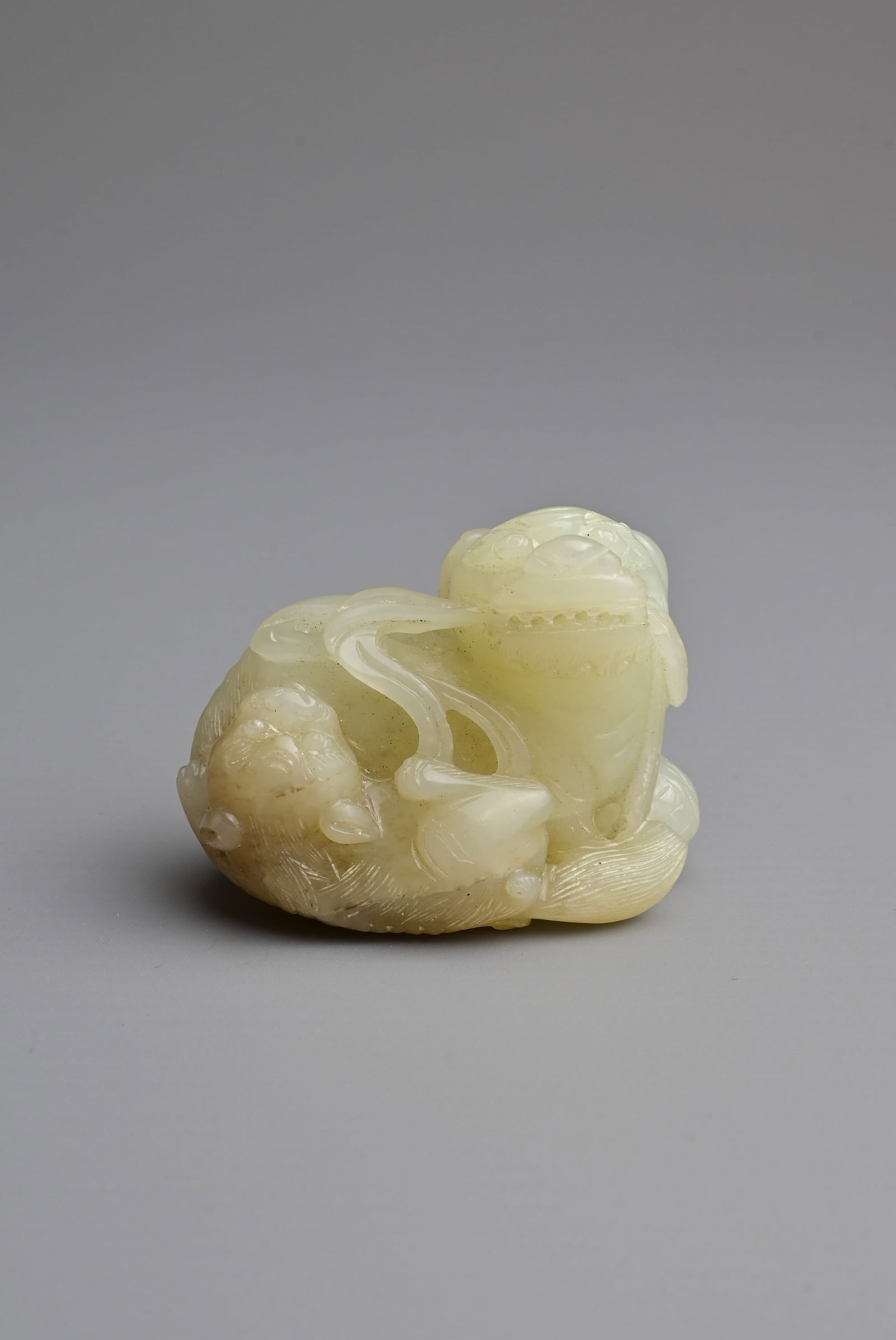 A CHINESE PALE CELADON JADE LION GROUP, QING DYNASTY, 19TH CENTURY. In the form of a recumbent (1 of 6)