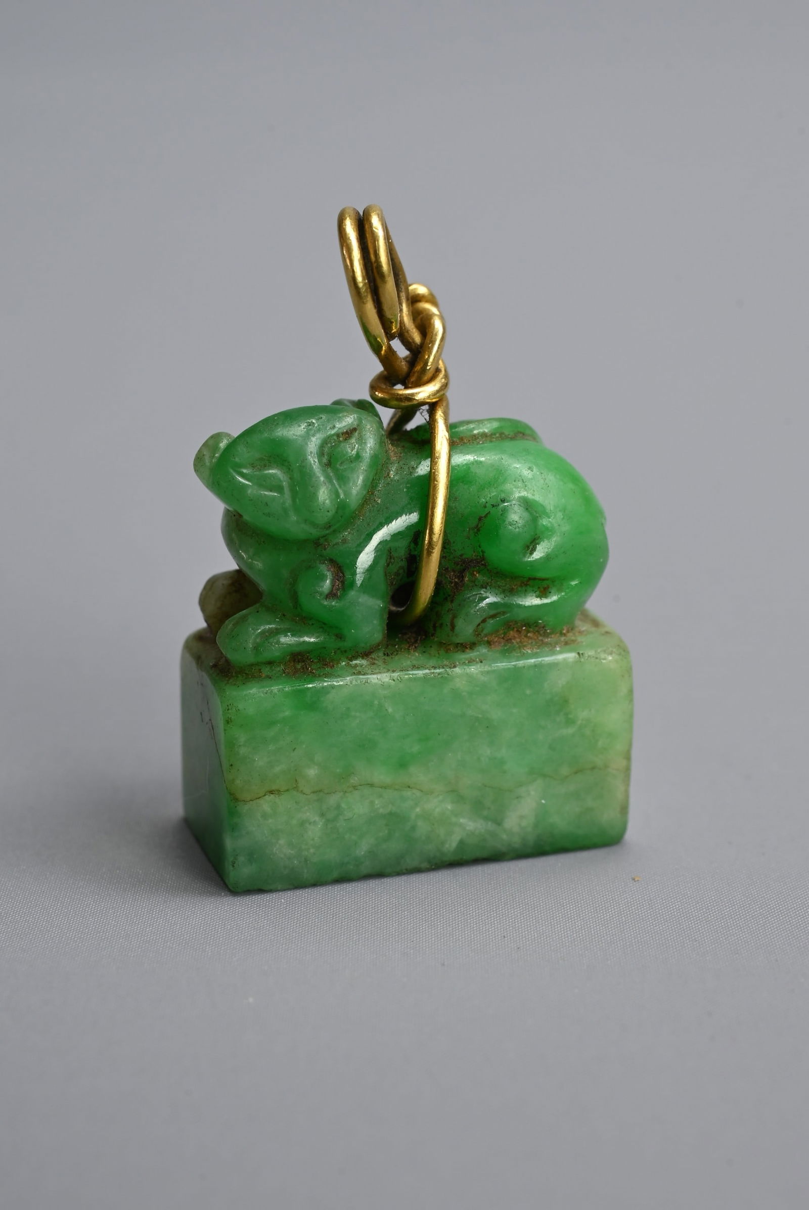 A SMALL CHINESE JADEITE SEAL PENDANT, LATE QING DYNASTY. Surmounted by a recumbent lion. Incised two (1 of 7)