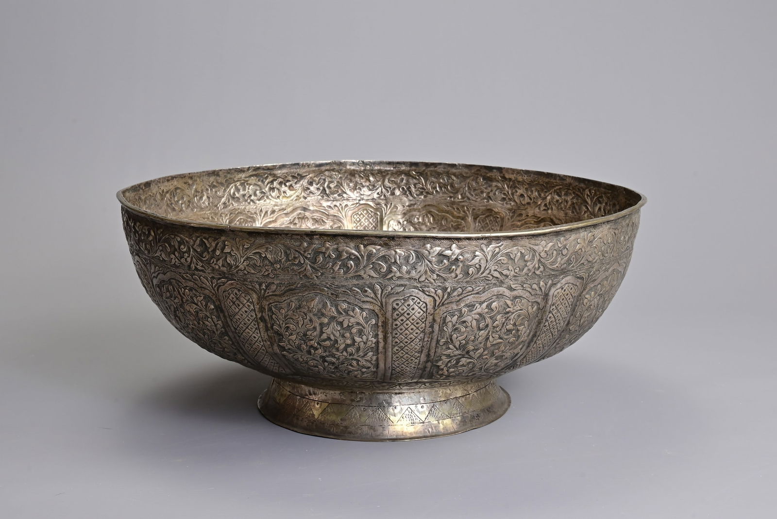 A MALAY ARCHIPELAGO SILVER ALLOY DEEP FOOTED BOWL, EARLY 20TH CENTURY. Embossed and engraved with (1 of 6)