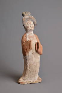 A CHINESE PAINTED POTTERY FIGURE OF COURT LADY, TANG DYNASTY (AD 618-907). Modelled standing wearing: A CHINESE PAINTED POTTERY FIGURE OF COURT LADY, TANG DYNASTY (AD 618-907). Modelled standing wearing a long flowing robe, her coiffured hair high on her head, her features picked out in black and robe