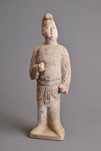 A CHINESE PAINTED POTTERY FIGURE OF AN ATTENDANT, TANG DYNASTY (AD 618-907). Modelled standing: A CHINESE PAINTED POTTERY FIGURE OF AN ATTENDANT, TANG DYNASTY (AD 618-907). Modelled standing wearing sash-tied robe, his hair curled high on his head and his features picked out in black and red, wi