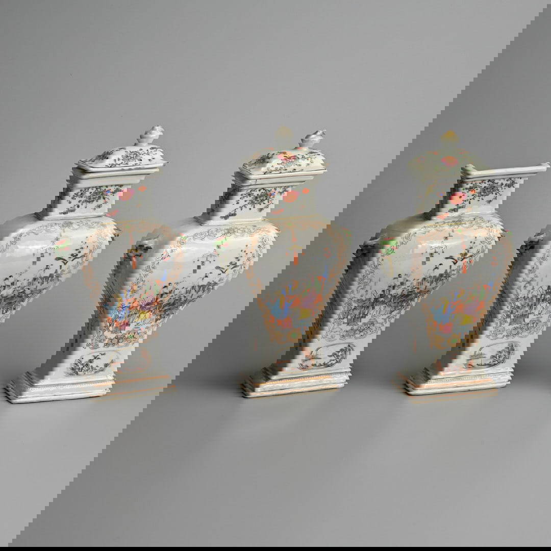 A GARNITURE OF THREE CHINESE EXPORT FAMILLE ROSE PORCELAIN INVERTED BALUSTER VASES AND TWO COVERS,