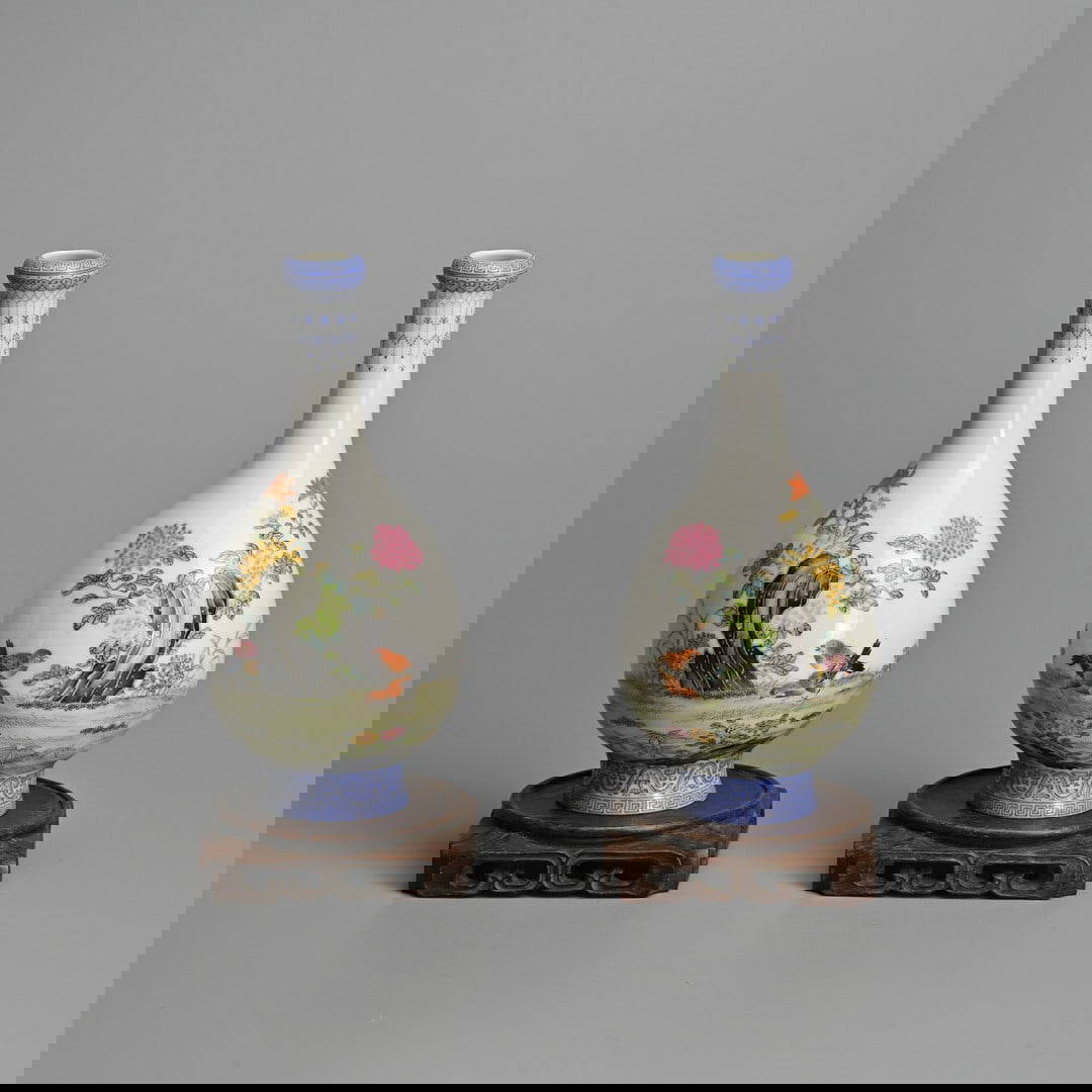 A FINE MIRRORED PAIR OF CHINESE FAMILLE ROSE PORCELAIN BOTTLE VASES WITH WOODEN STANDS, QIANLONG