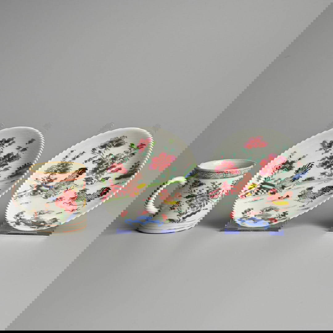 TWO CHINESE EXPORT FAMILLE ROSE PORCELAIN SAUCERS AND A SMALL CYLINDRICAL MUG, EARLY 18TH CENTURY.