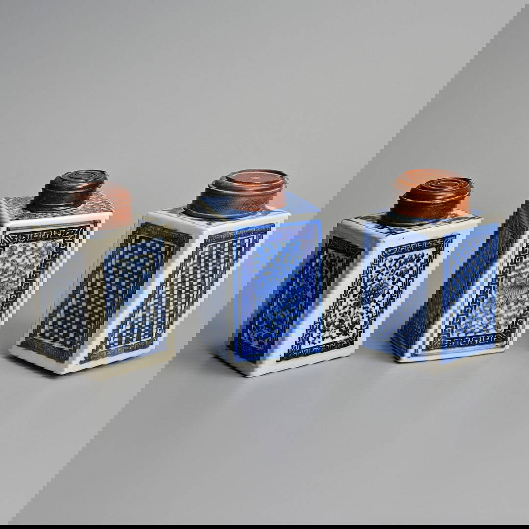 THREE CHINESE BLUE AND WHITE SQUARE SECTION PORCELAIN TEA CADDIES AND HARDWOOD COVERS, 19TH CENTURY.