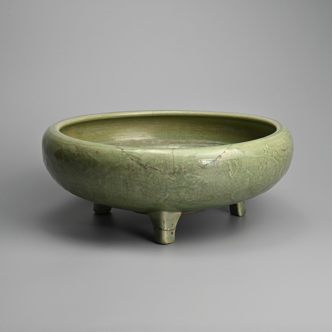 A CHINESE LONGQUAN CELADON GLAZED AND INCISED PORCELAIN TRIPOD CENSER, MING DYNASTY (1368-1644).