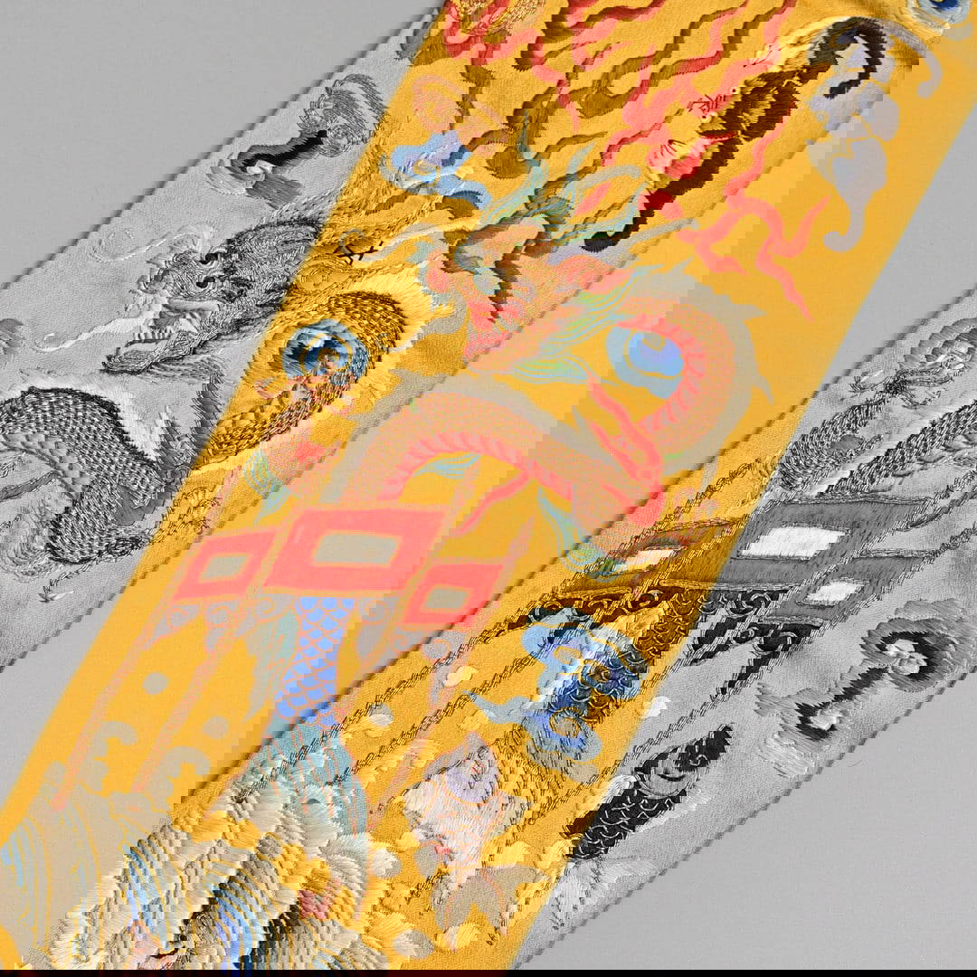 A CHINESE GOLD GROUND EMBROIDERED SILK SLEEVE CUFF, QING DYNASTY.