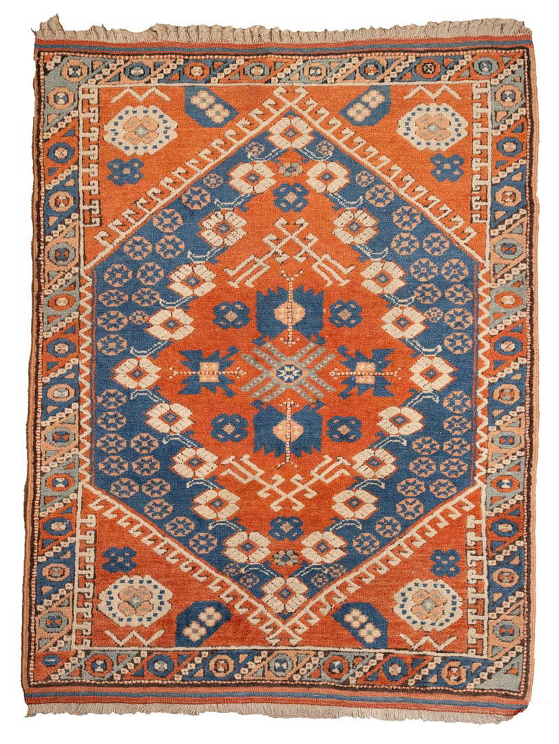 AN ANTIQUE CAUCASIAN WOOL RUG, EARLY 20TH CENTURY.