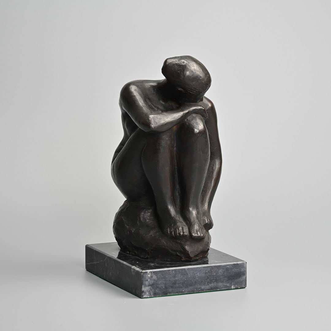AFTER SHAZABURO YASUDA (1906-1981) BRONZE FIGURE OF A CROUCHING FEMALE NUDE, ON BLACK STONE PLINTH.