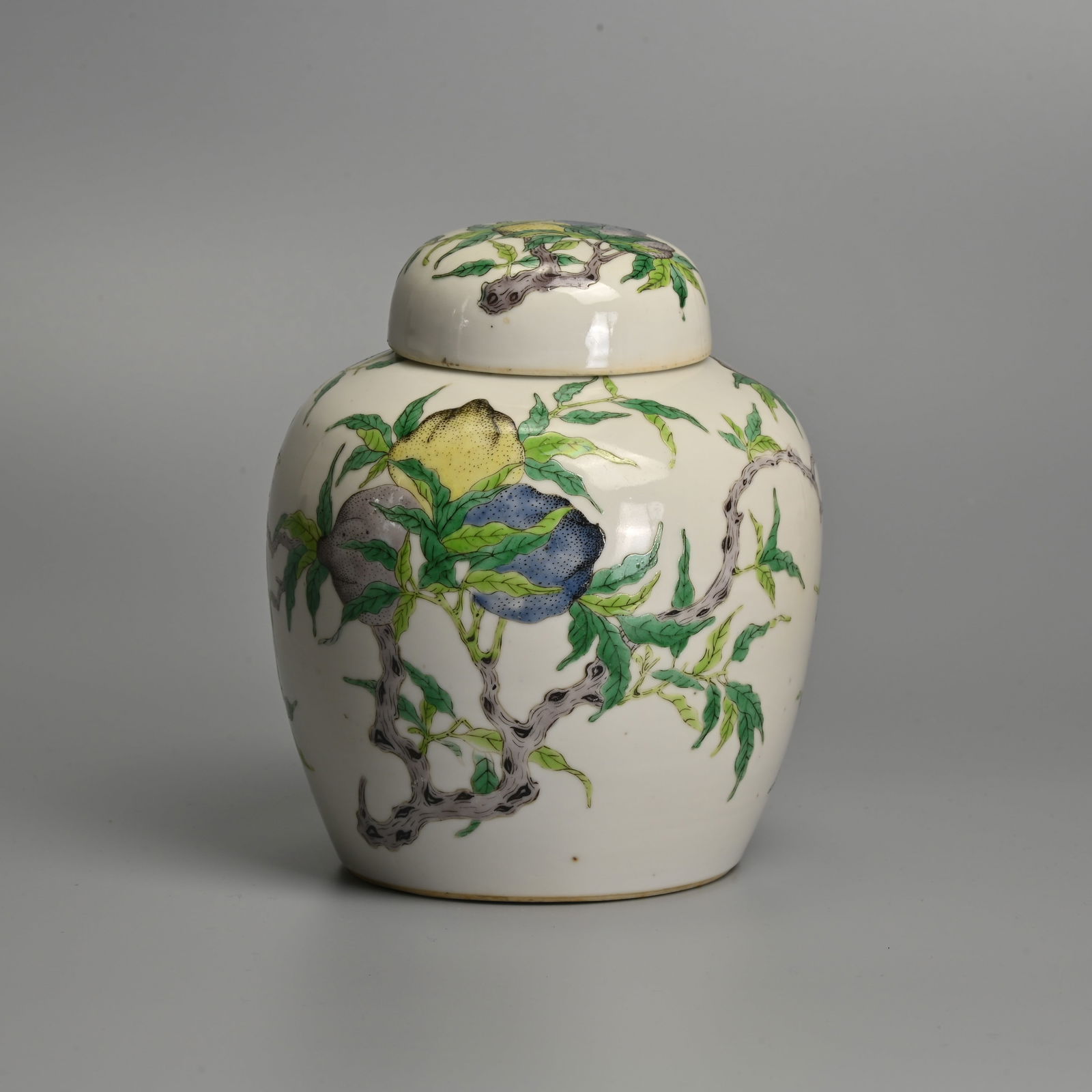 A CHINESE FAMILLE VERTE PORCELAIN 'FRUIT' JAR AND COVER, QING DYNASTY.: A CHINESE FAMILLE VERTE PORCELAIN 'FRUIT' JAR AND COVER, QING DYNASTY. Of ovoid form decorated with fruit on leafy branches, with matching cover. Six-character mark of Kangxi to base in underglaze blu