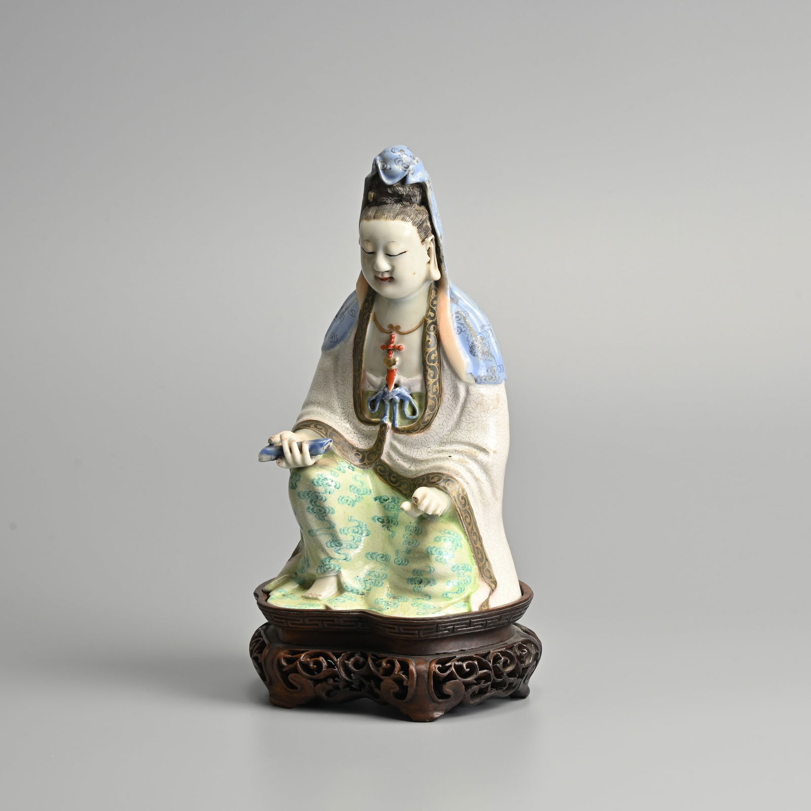 A CHINESE FAMILLE ROSE PORCELAIN FIGURE OF GUANYIN ON HARDWOOD STAND, QING DYNASTY. (1 of 10)