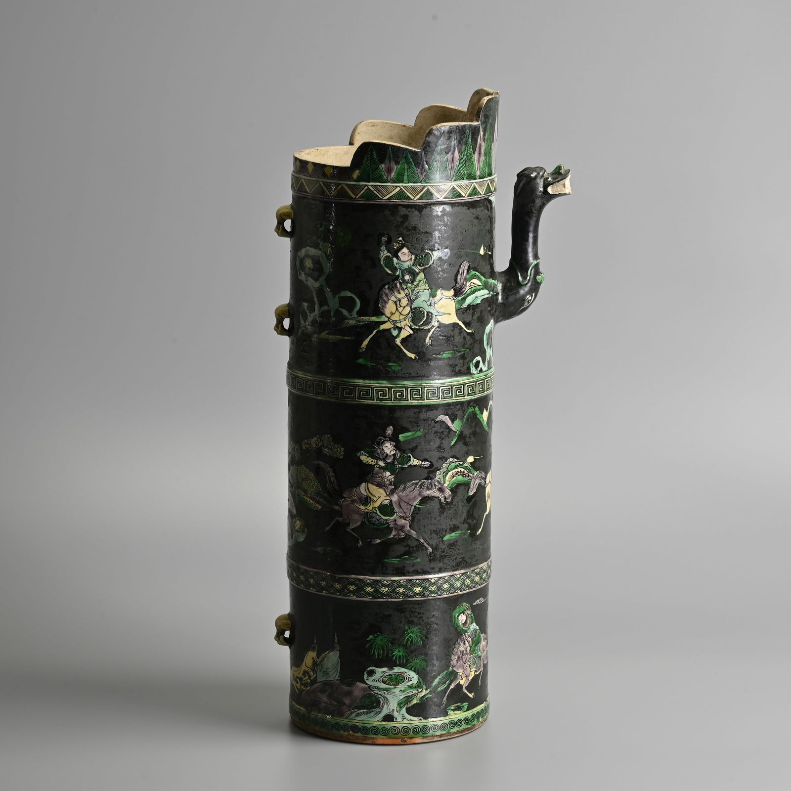 A LARGE CHINESE FAMILLE NOIRE PORCELAIN EWER WITH COVER, DUOMUHU, QING DYNASTY.: A LARGE CHINESE FAMILLE NOIRE PORCELAIN EWER WITH COVER, DUOMUHU, QING DYNASTY. Of tall cylindrical form with a lobed 'monk's cap' above with dragon head spout and three lion masks loops to the body.
