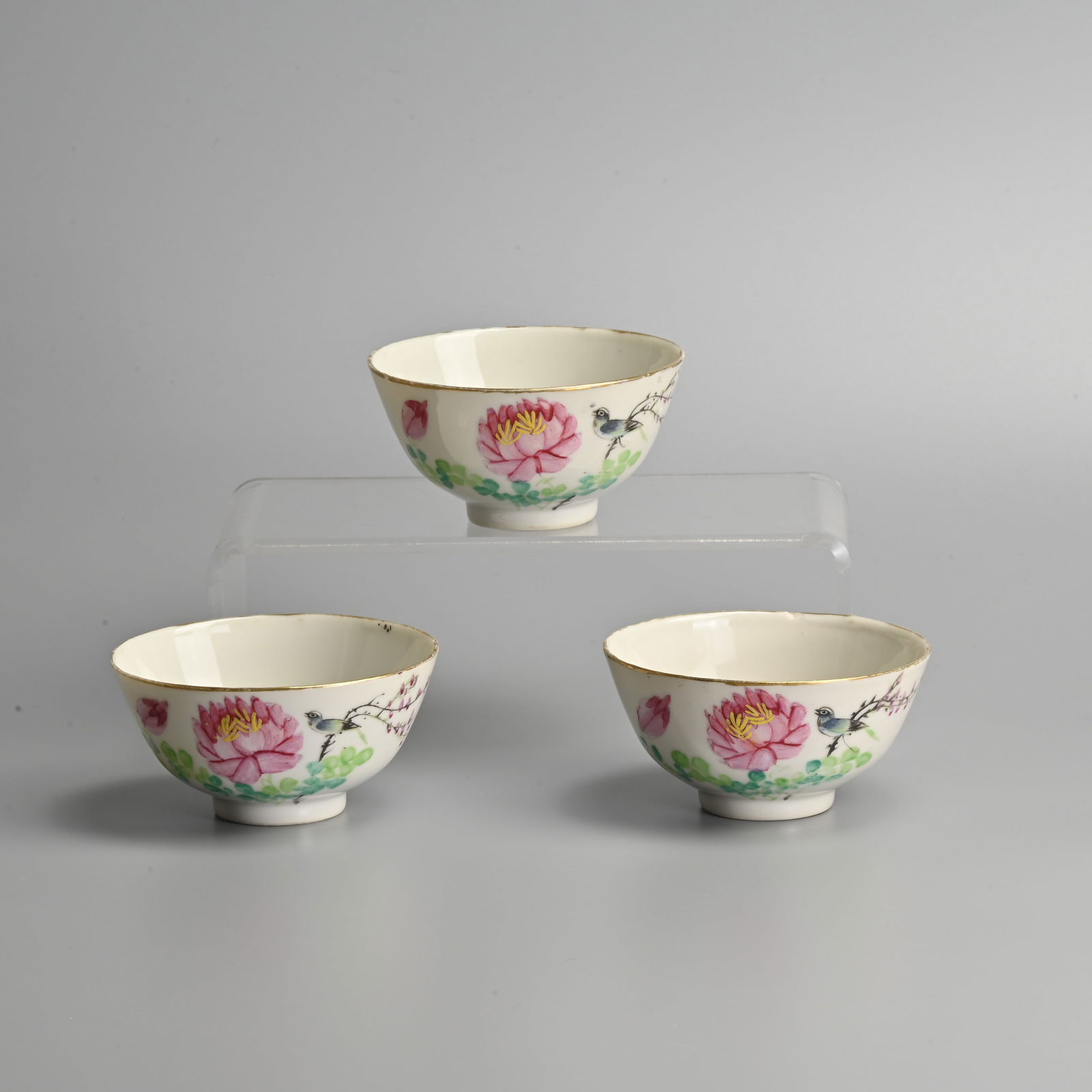 THREE CHINESE PORCELAIN FAMILLE ROSE BOWLS, MID-20TH CENTURY.: THREE CHINESE PORCELAIN FAMILLE ROSE BOWLS, MID-20TH CENTURY. Each painted with a bird perched amongst pink flowers and green leaves, inscribed in black calligraphic script, each with printed red over