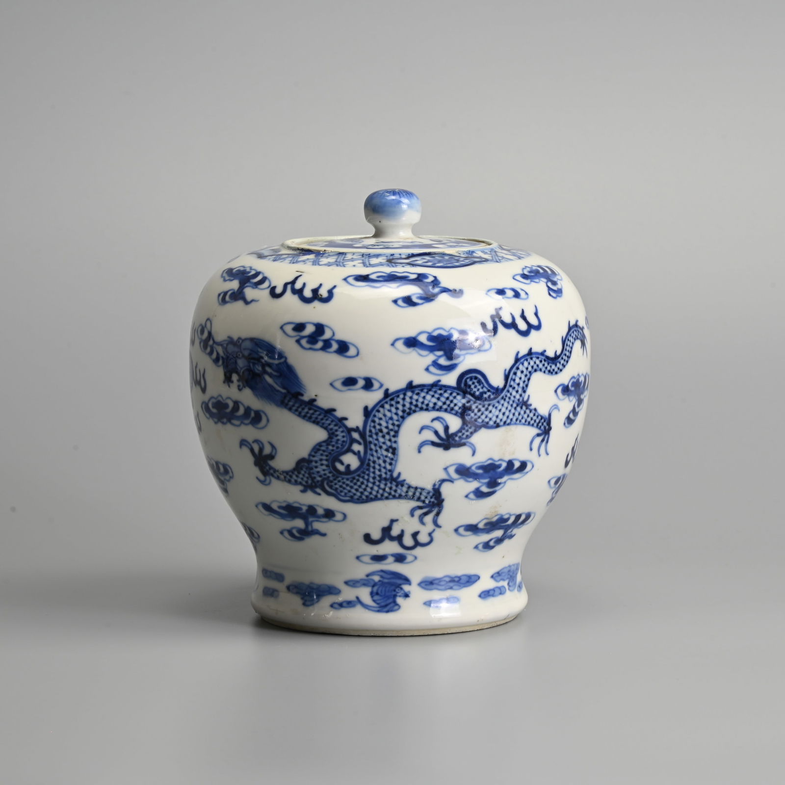 A CHINESE BLUE AND WHITE PORCELAIN JAR AND COVER, 19/20TH CENTURY.: A CHINESE BLUE AND WHITE PORCELAIN JAR AND COVER, 19/20TH CENTURY. Decorate with two dragons chasing a flaming pearl amidst clouds, together with original cover. Four-character Kangxi mark to base. 17