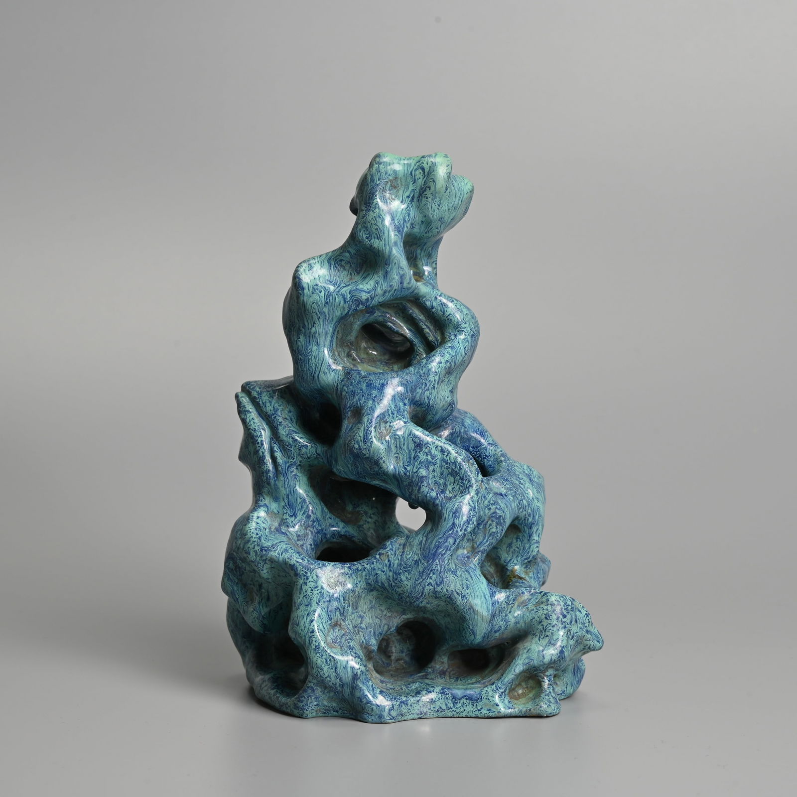 A CHINESE ROBIN'S EGG GLAZED STONEWARE MODEL OF A 'TAIHU SCHOLAR'S ROCK'.: A CHINESE ROBIN'S EGG GLAZED STONEWARE MODEL OF A 'TAIHU SCHOLAR'S ROCK'. Covered in a turquoise-blue glaze with purple cascades. 19cm tall. Condition: In good overall condition with no signs of damag