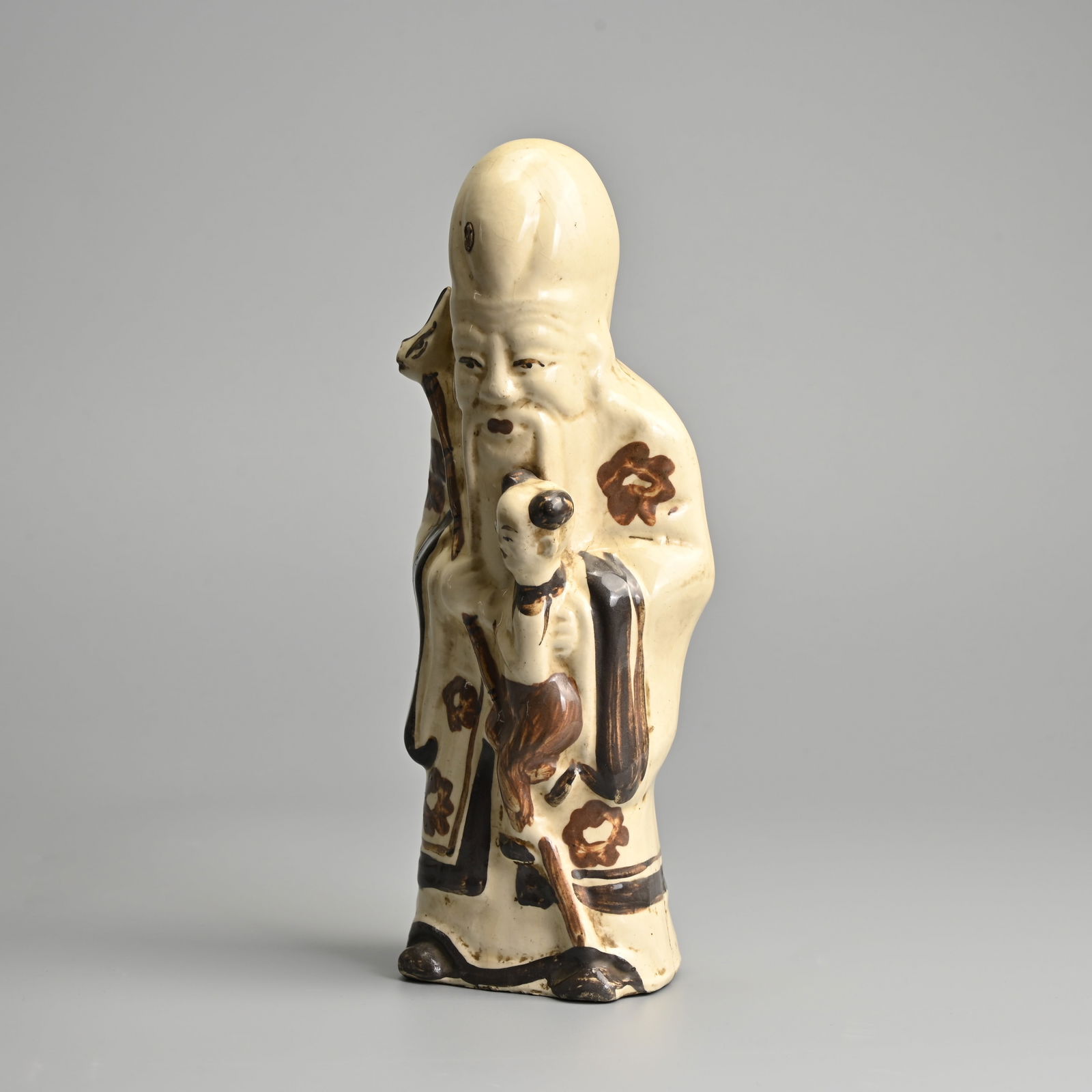 A CHINESE CIZHOU POTTERY FIGURE OF SHOULAO WITH CHILD, LATE MING DYNASTY. (1 of 9)