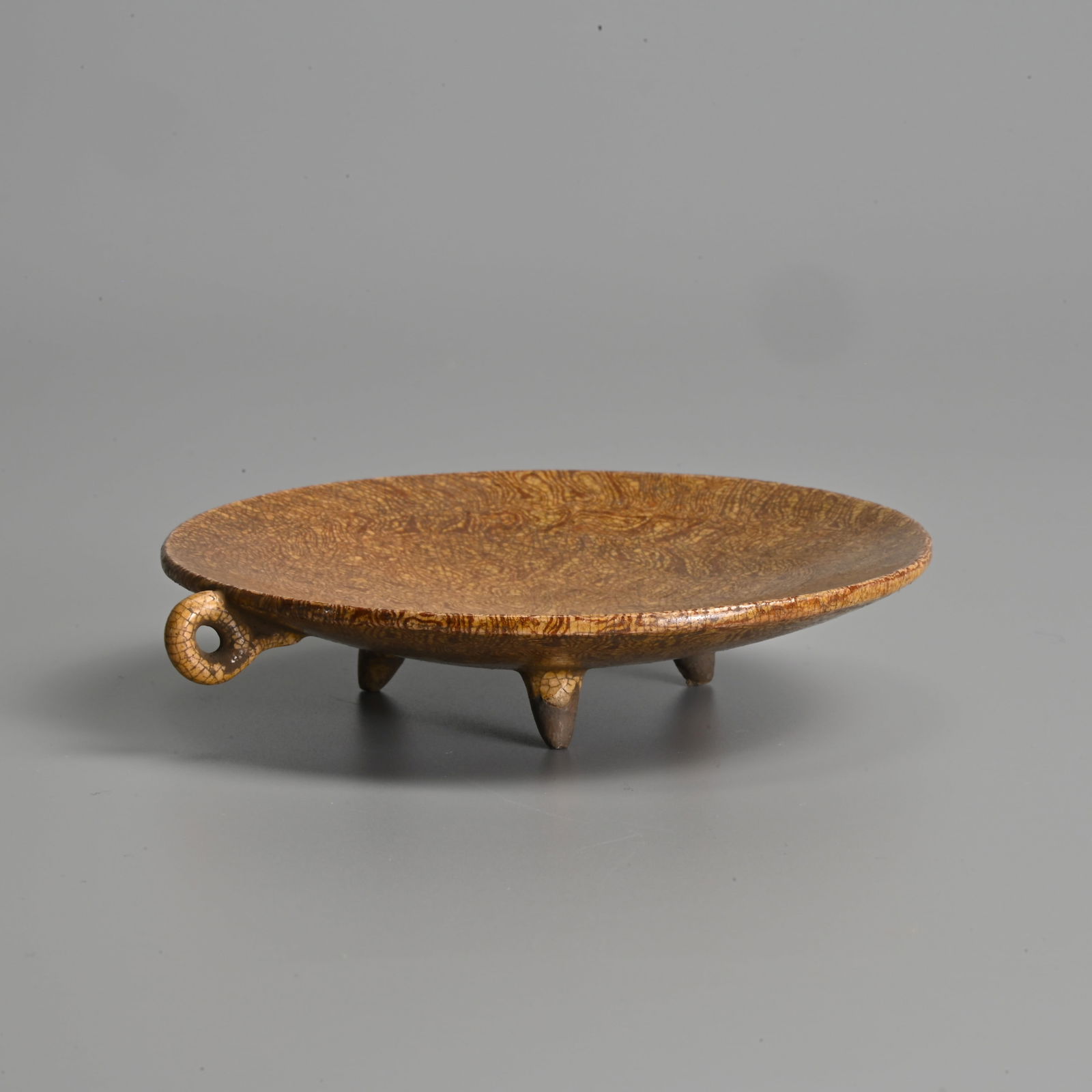 A CHINESE AMBER GLAZED POTTERY HANDLED TRIPOD DISH. (1 of 5)