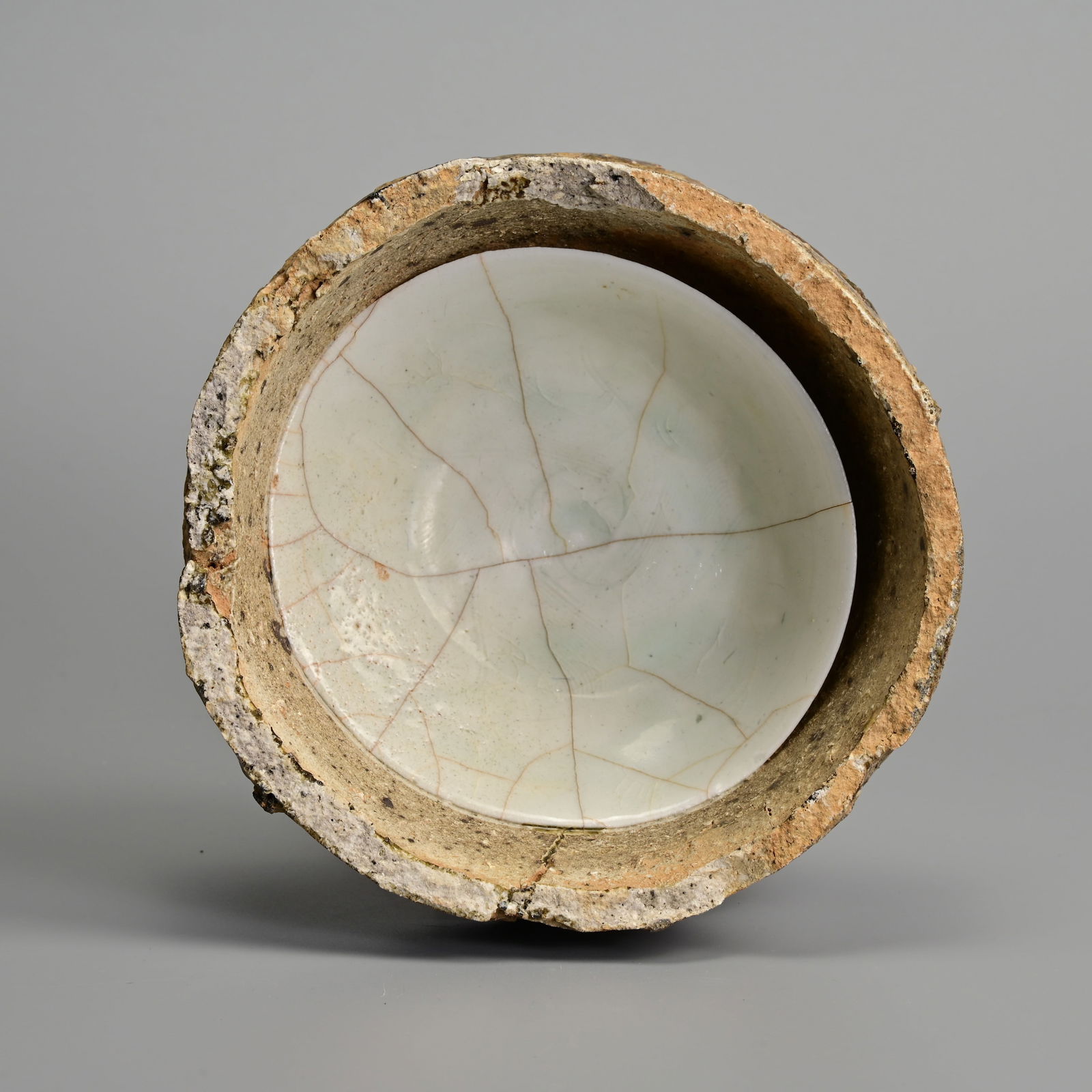 A CHINESE NORTHERN SONG DYNASTY QINGBAI PORCELAIN DISH IN KILN SAGGAR (AD 960-1127). (1 of 6)