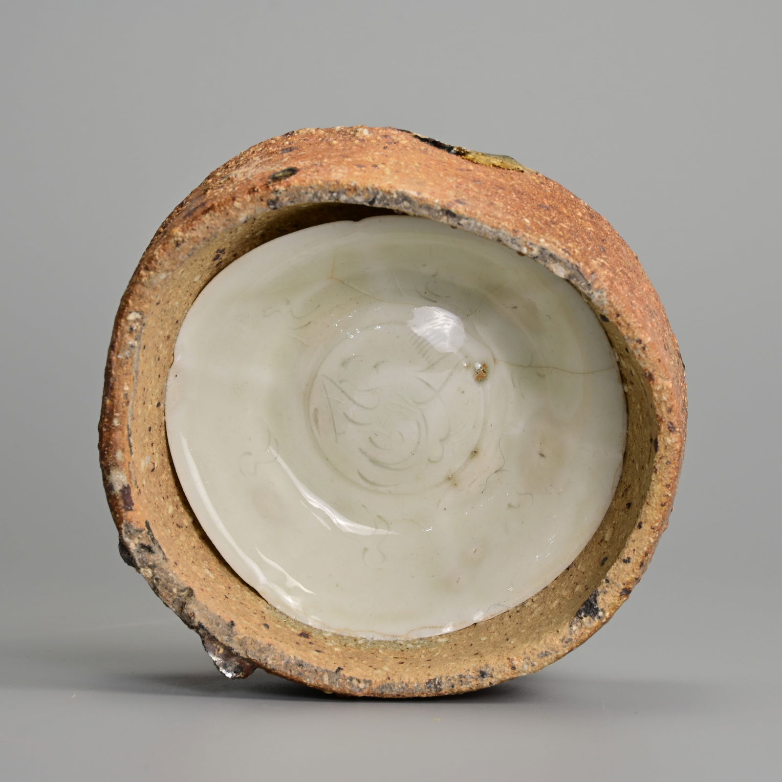 A CHINESE NORTHERN SONG DYNASTY QINGBAI PORCELAIN DISH IN KILN SAGGAR (AD 960-1127). (1 of 5)