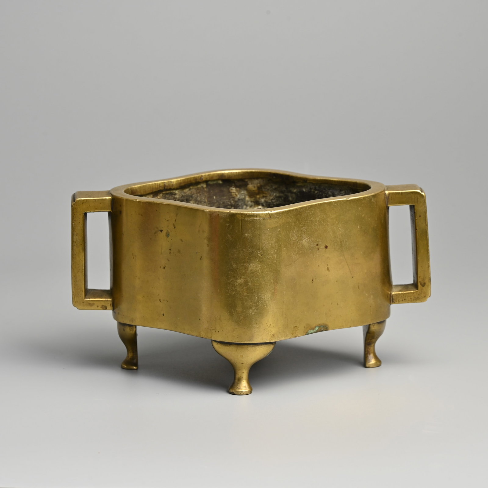 A CHINESE BRONZE QUATREFOIL CENSER, QING DYNASTY, QING DYNASTY.: A CHINESE BRONZE QUATREFOIL CENSER, QING DYNASTY, QING DYNASTY. With twin handles raised on four feet. Six-character seal of mark of Xuande to base. 18.5cm wide including handles. Weight 1.54KG. Condi