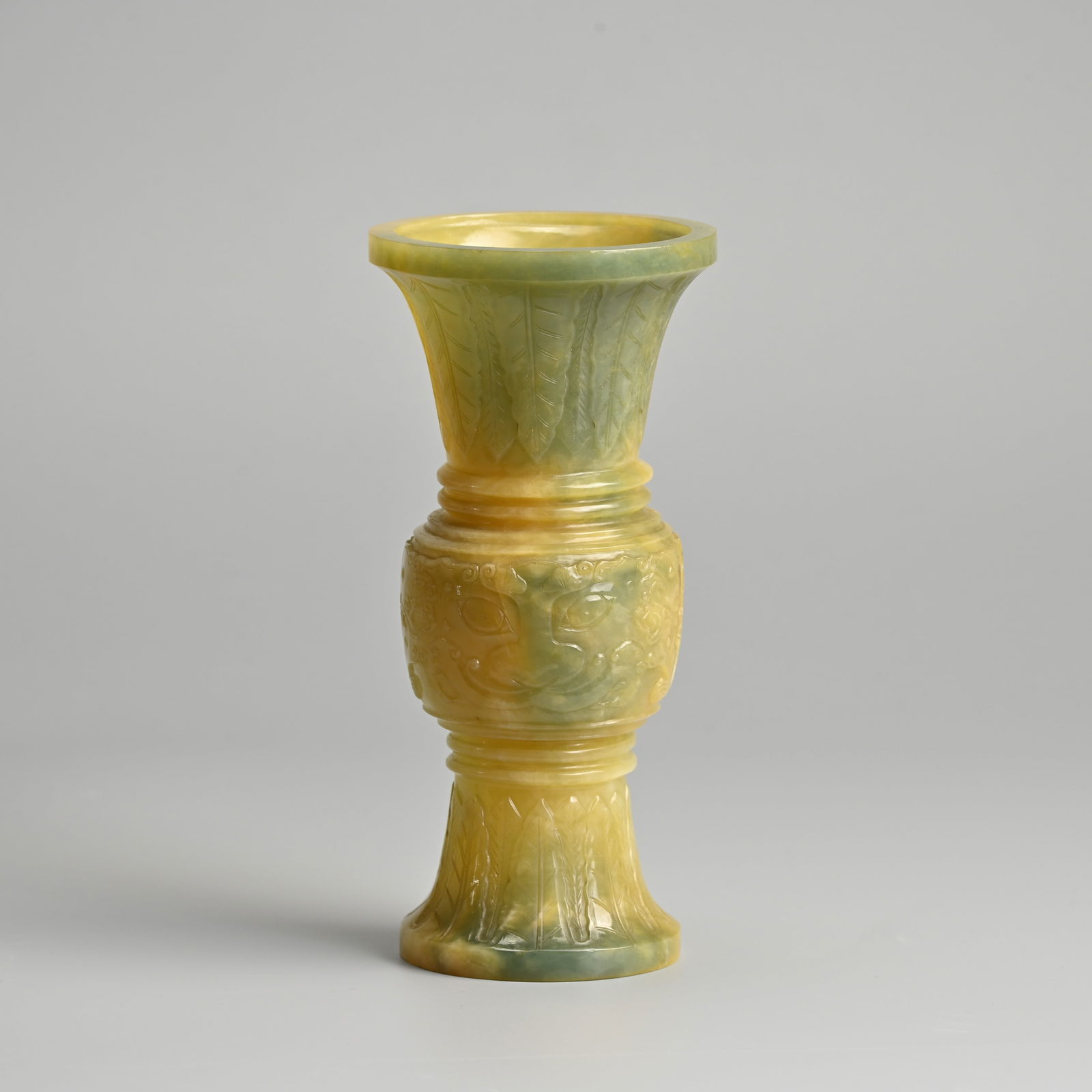 A CHINESE CARVED CELADON JADE 'TAOTIE' GU FORM VASE. (1 of 8)