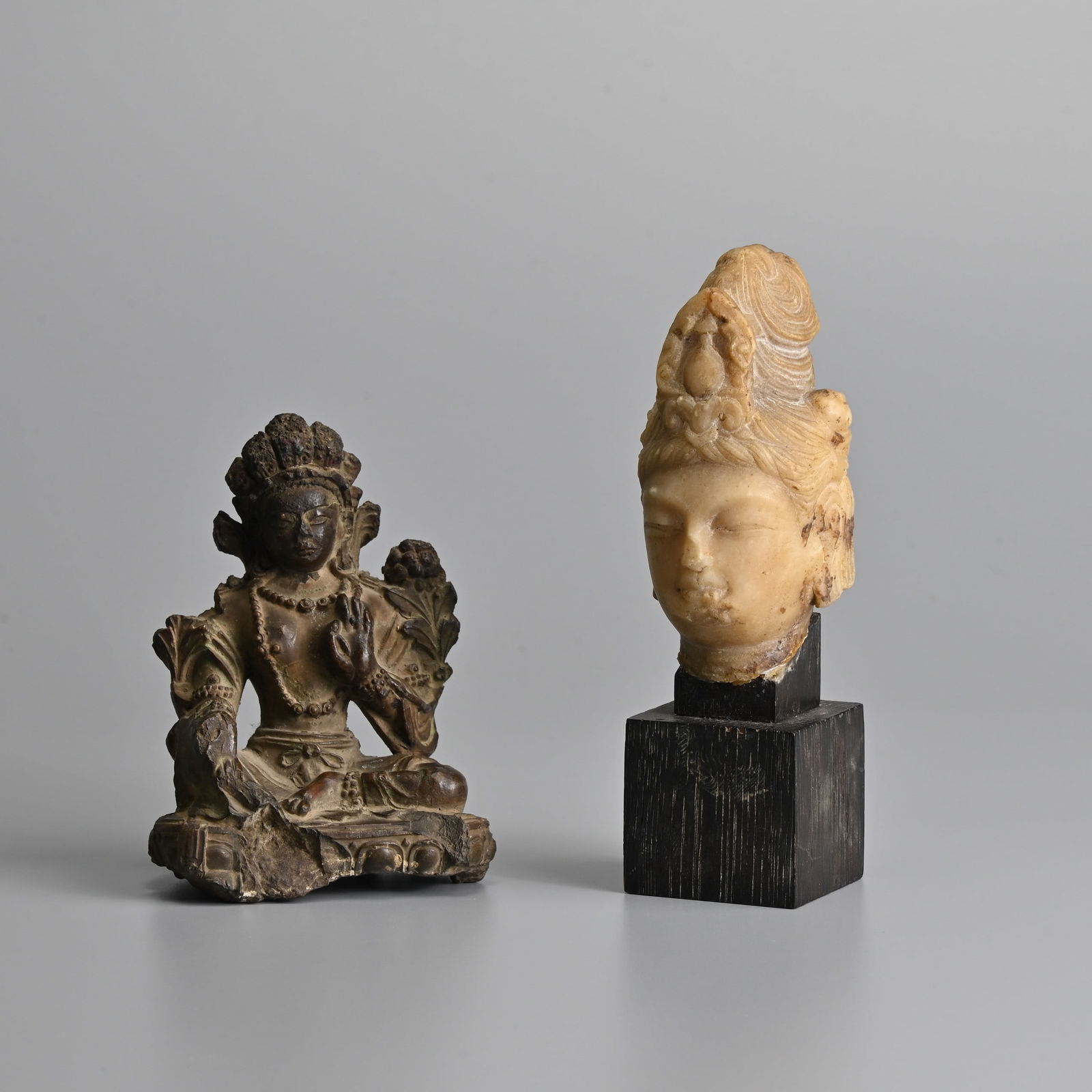A CHINESE CARVED SOAPSTONE HEAD OF GUANYIN WITH A CERAMIC FIGURE OF A SEATED TARA. (1 of 15)