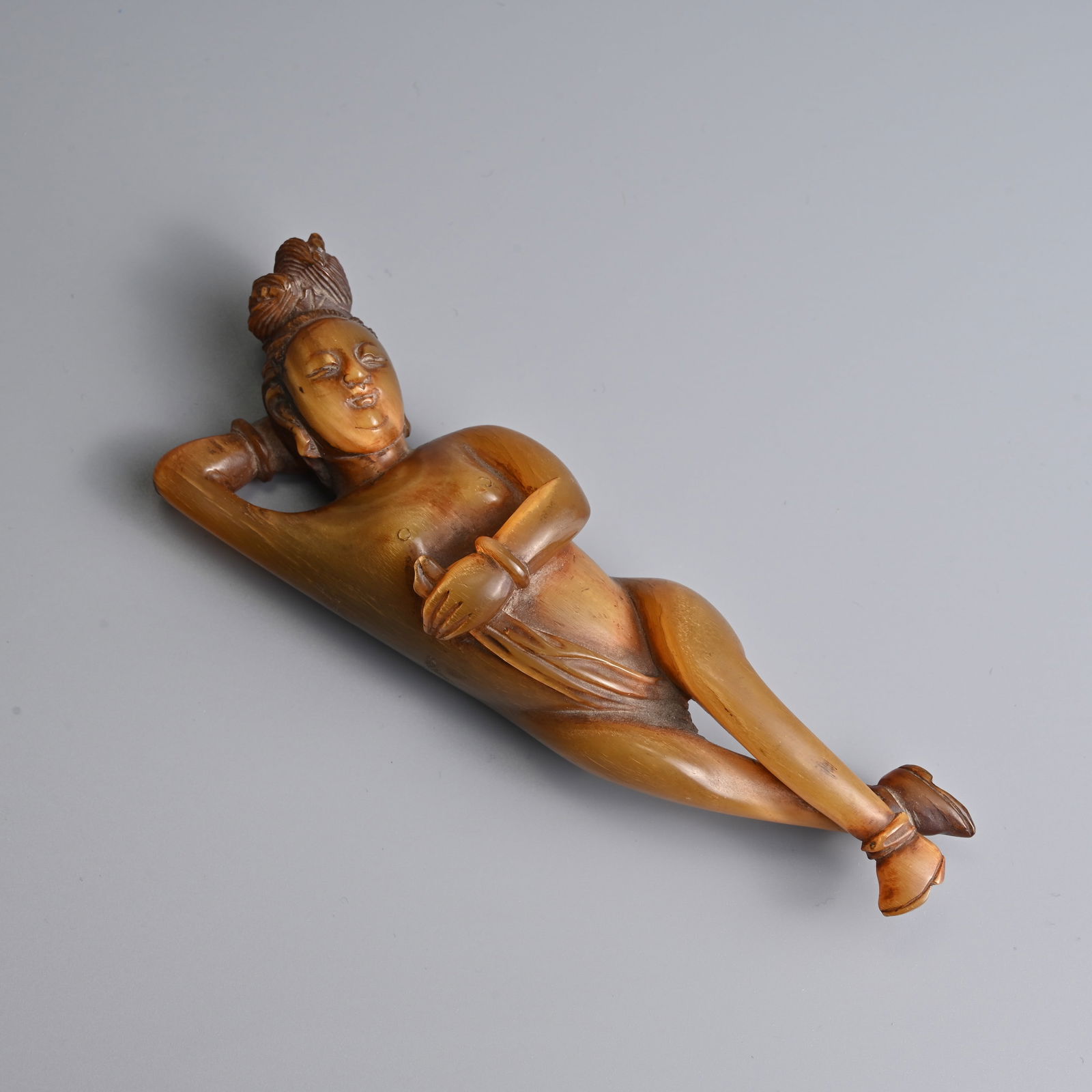 A CHINESE CARVED HORN DOCTOR'S LADY, QING / REPUBLIC PERIOD.: A CHINESE CARVED HORN DOCTOR'S LADY, QING / REPUBLIC PERIOD. Model of a reclining nude lady with one arm across her body holding a textile and the other supporting her head. 14cm length. Weight 71 gra