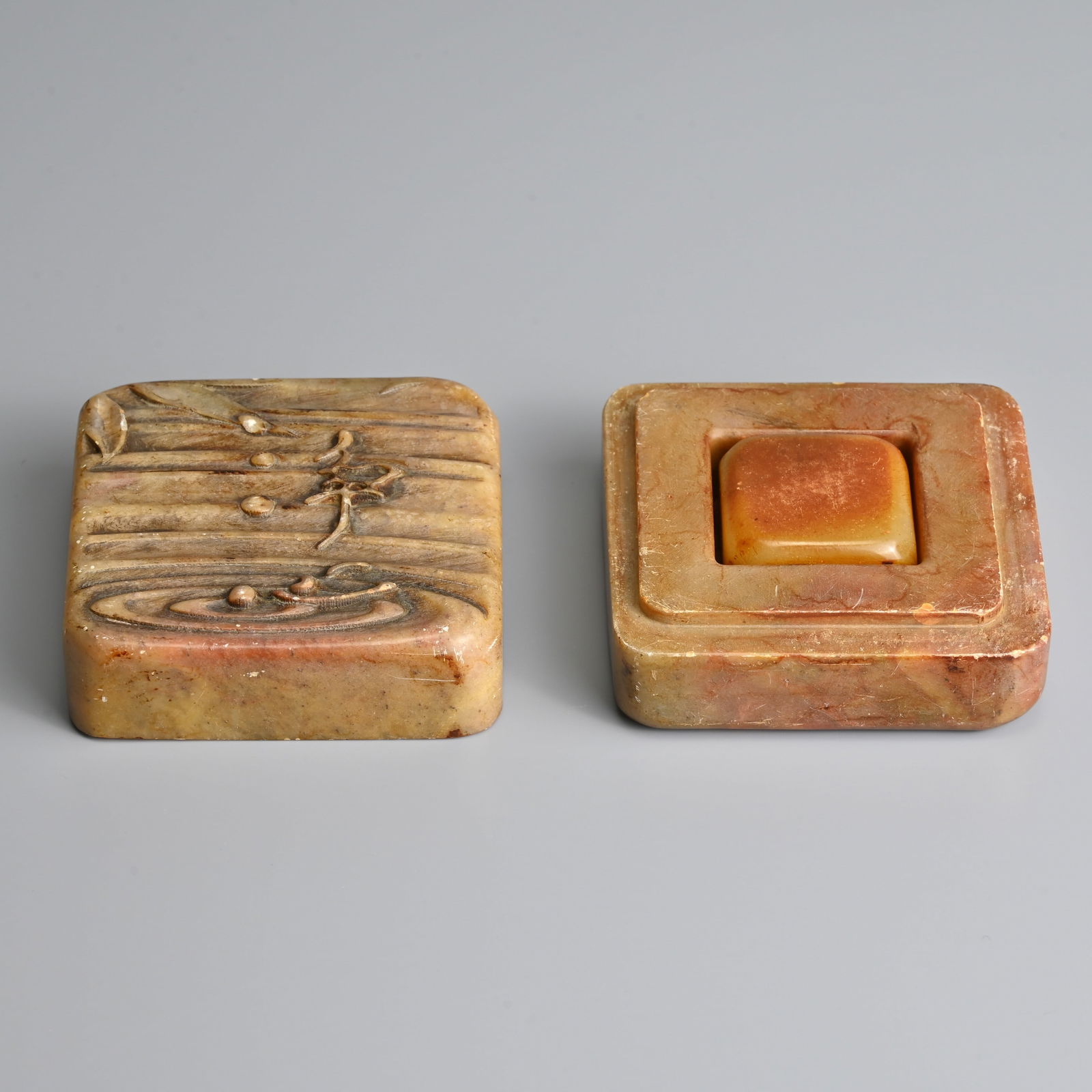 A CHINESE CARVED SOAPSTONE SEAL BOX AND COVER WITH SEAL, 20TH CENTURY.: A CHINESE CARVED SOAPSTONE SEAL BOX AND COVER WITH SEAL, 20TH CENTURY. The box of square form carved in relief to the cover with water droplets dropping from a leaf into water. The base inscribed. A s