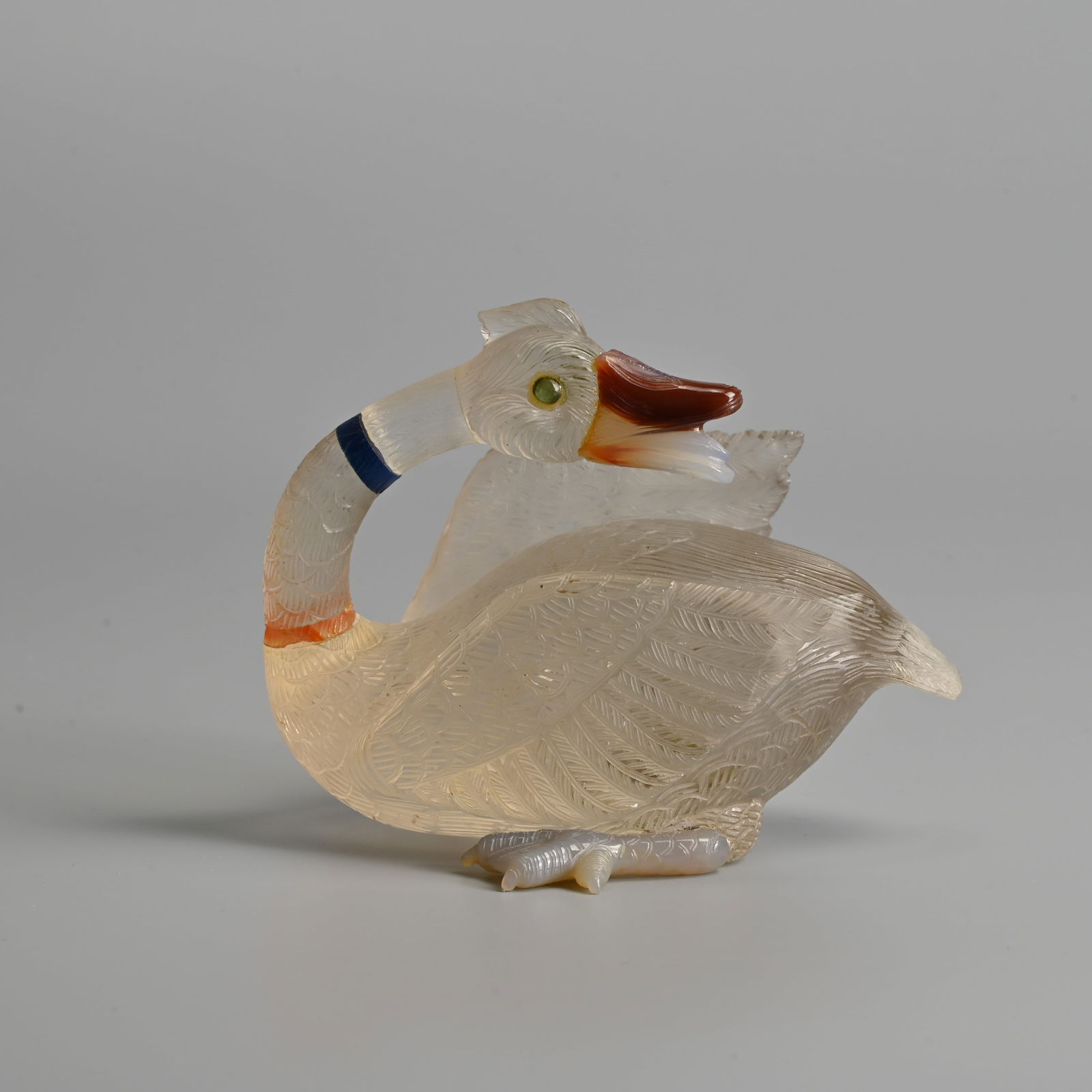 A CHINESE CARVED SECTIONAL ROCK CRYSTAL AND AGATE MODEL OF AN EGRET, 20TH CENTURY.: A CHINESE CARVED SECTIONAL ROCK CRYSTAL AND AGATE MODEL OF AN EGRET, 20TH CENTURY. Seated on carved feet with its head turned towards its back. 12cm length. Condition: The beak, feet and eyes are atta