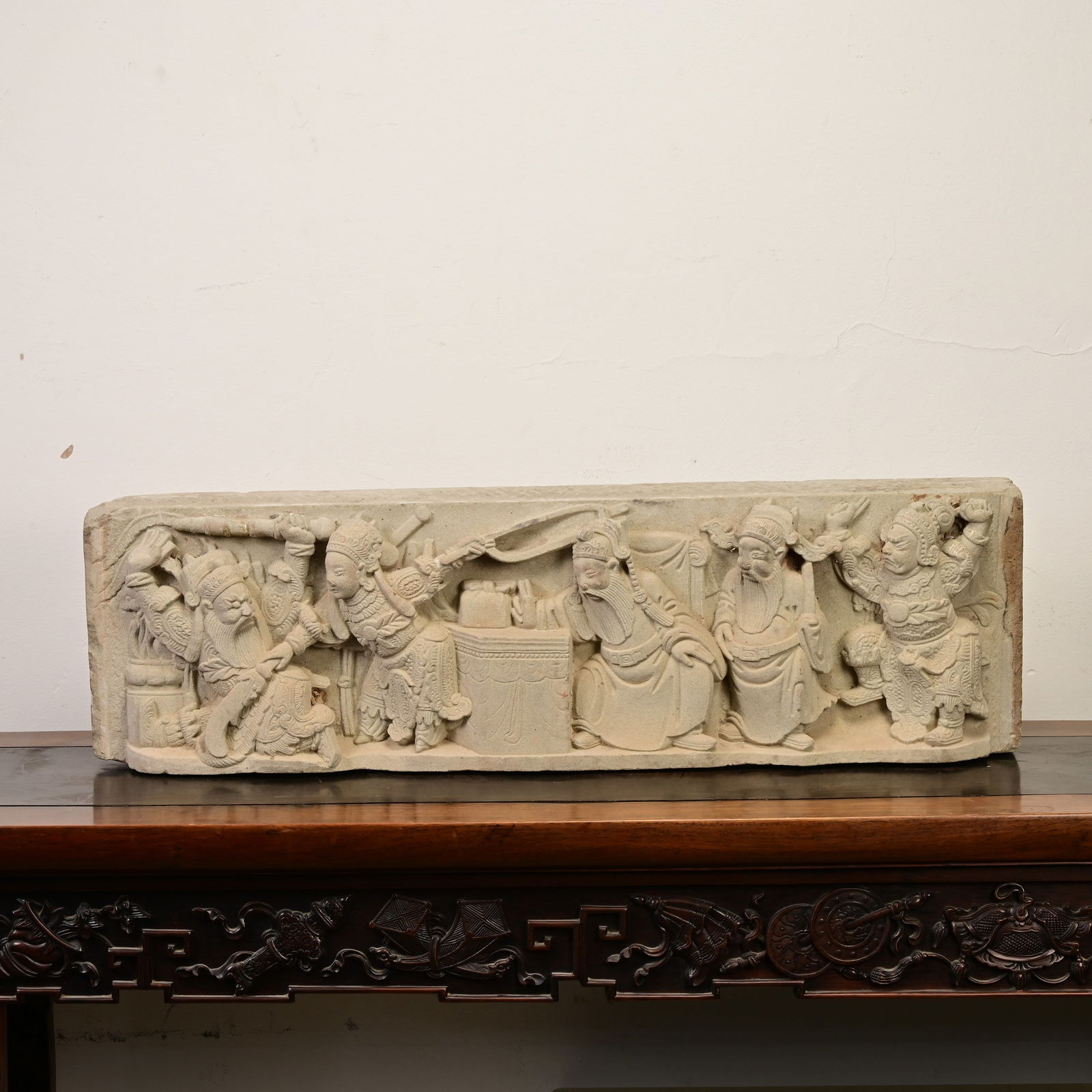 A LARGE CHINESE MING DYNASTY ARCHITECTURAL STONE FRIEZE (AD 1368 - 1644).: A LARGE CHINESE MING DYNASTY ARCHITECTURAL STONE FRIEZE (AD 1368 ' 1644). Deeply carved in high relief depicting a highly animated scene featuring five elaborately dressed immortals. Length 76 cm x he