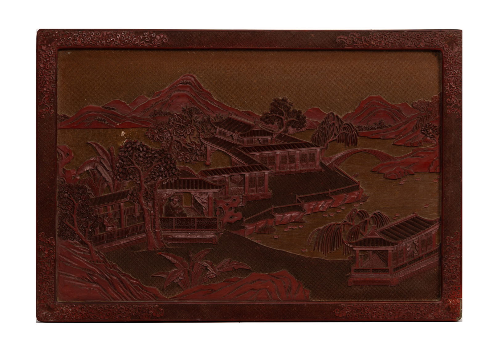 A LARGE CHINESE CARVED CINNABAR LACQUER PANEL, 19/20TH CENTURY.: A LARGE CHINESE CARVED CINNABAR LACQUER PANEL, 19/20TH CENTURY. Of rectangular form carved in relief featuring a scholar and attendant in a building beside a lake with mountainous landscape. Bordered