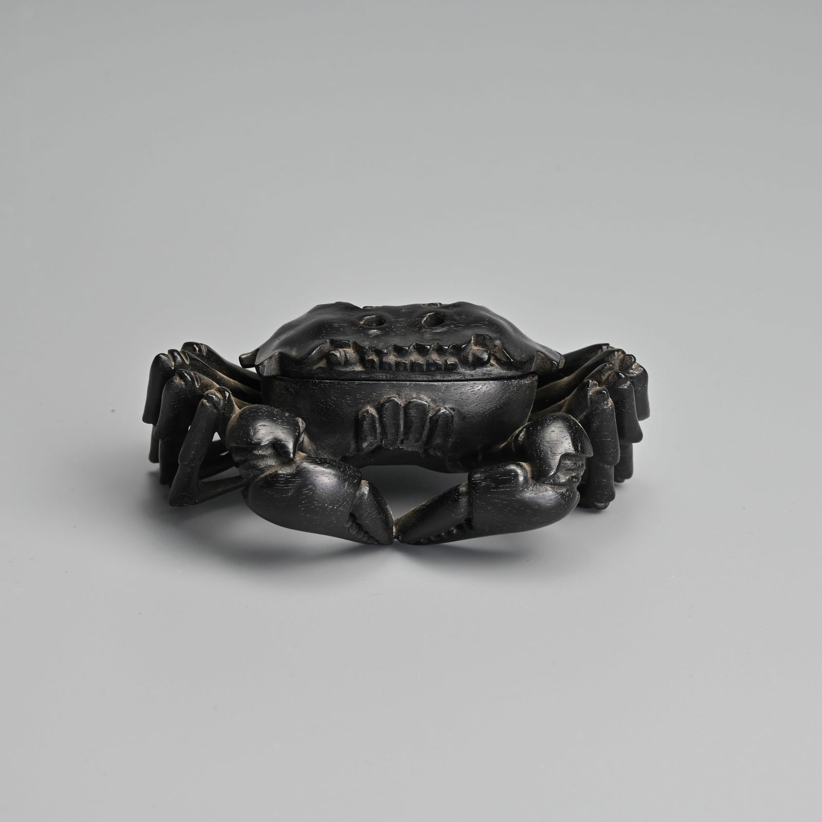 A CHINESE CARVED HARDWOOD BOX AND COVER IN THE FORM OF A MITTEN CRAB.: A CHINESE CARVED HARDWOOD BOX AND COVER IN THE FORM OF A MITTEN CRAB. With eight legs and two large claws. The head cover with pierced sections resembling lingzhi. 10.5cm wide. Condition: Good overall