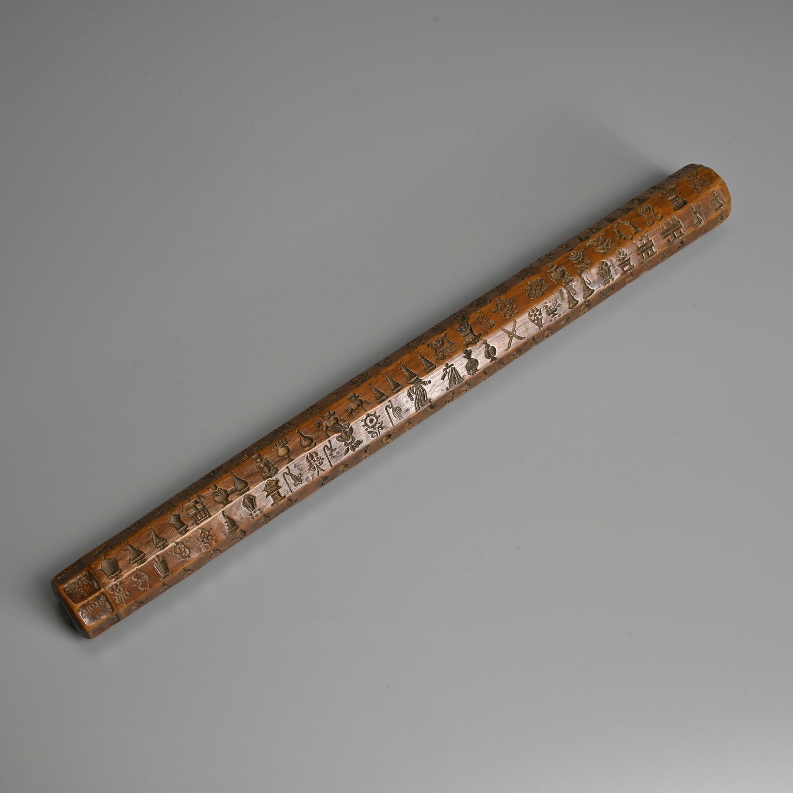 A TIBETAN CARVED WOOD 'ZAN PAR' MOULD, 19/20TH CENTURY.: A TIBETAN CARVED WOOD 'ZAN PAR' MOULD, 19/20TH CENTURY. Octagonal cylinder carved with rows of various Buddhist motifs to include Buddhist symbols, animals, birds, deities and astronomical motifs with