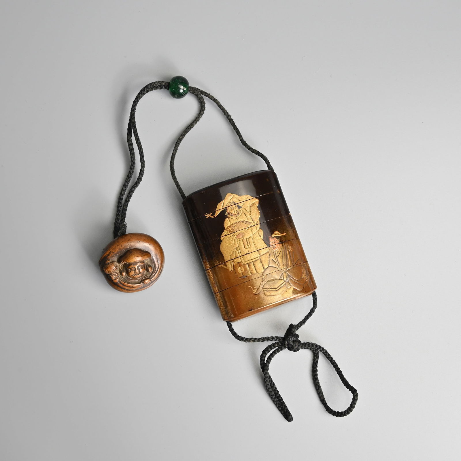 A JAPANESE ROUNDED RECTANGULAR FIVE-CASE DARK-BROWN, BLACK AND GOLD LACQUERED INRO, LATE MEIJI/EARLY (1 of 4)