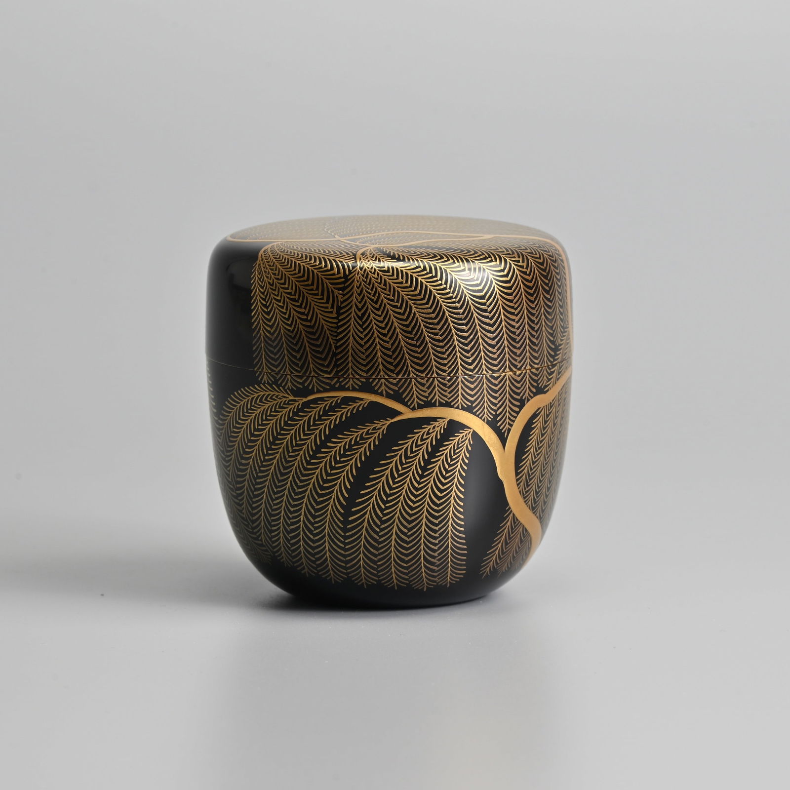 A JAPANESE BLACK AND GILT LACQUER TEACADDY AND COVER (NATSUME), LATE 20TH CENTURY.: A JAPANESE BLACK AND GILT LACQUER TEACADDY AND COVER (NATSUME), LATE 20TH CENTURY. Decorated with willow, Katsura Hiroshi, in wooden box, 7.5 cm high. Condition: In good order.