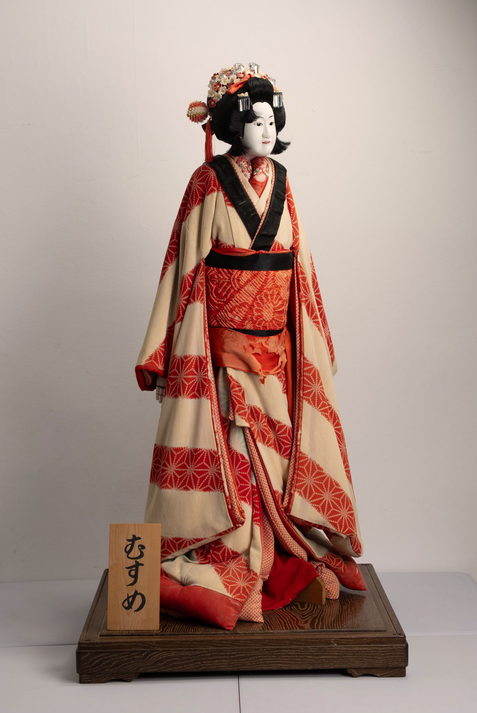 A LARGE JAPANESE BUNRAKU PUPPET OF YAOYA OSHICHI, SHOWA PERIOD (1926-1989).: A LARGE JAPANESE BUNRAKU PUPPET OF YAOYA OSHICHI, SHOWA PERIOD (1926-1989). The puppet standing, wearing a long red, cream and blue silk kimono, with silk flowers and metal ornaments in her black hair