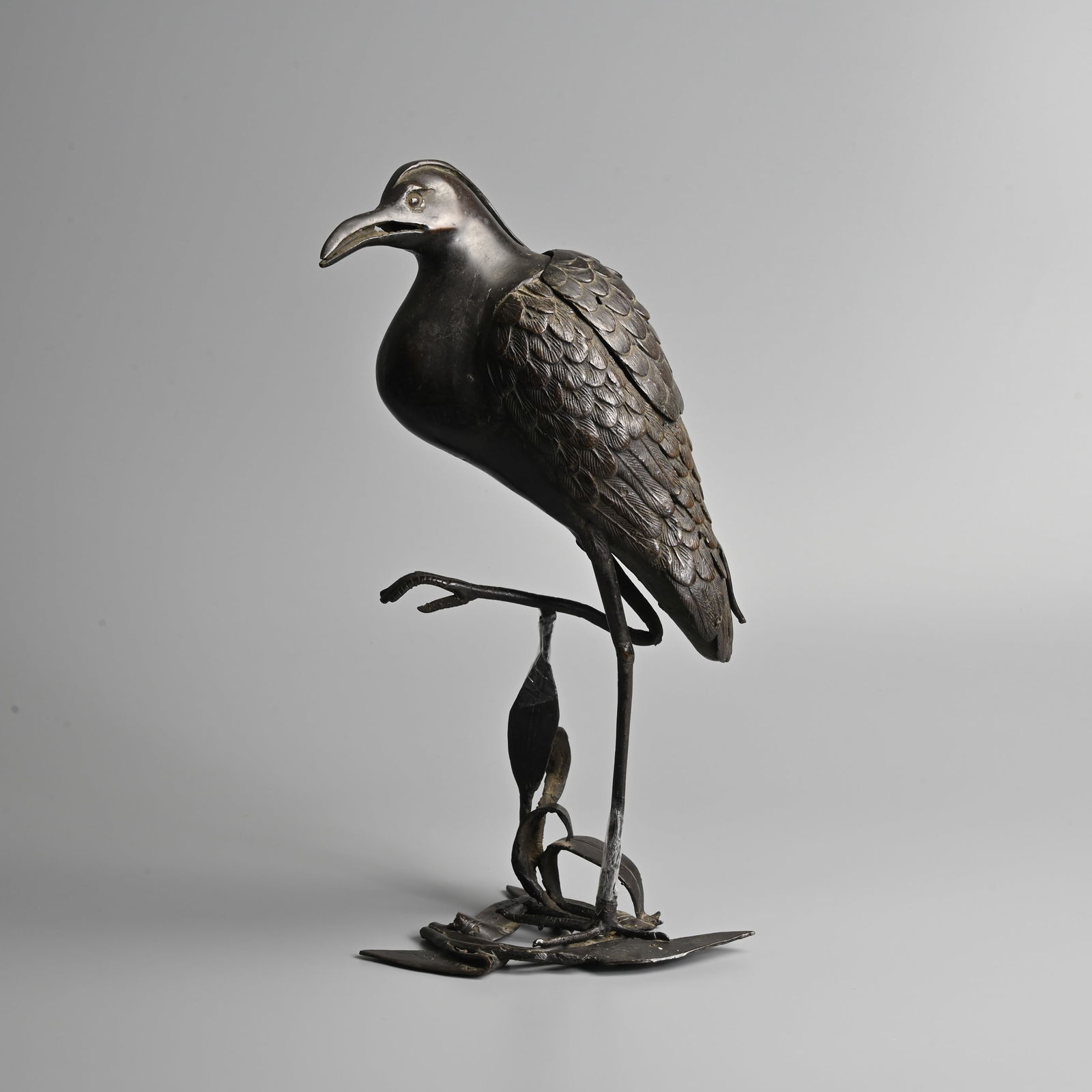 A LARGE JAPANESE BRONZE INCENSE BURNER AND COVER IN THE FORM OF AN EGRET, MEIJI PERIOD.: A LARGE JAPANESE BRONZE INCENSE BURNER AND COVER IN THE FORM OF AN EGRET, MEIJI PERIOD. Modelled standing on a leafy branch with one foot raised. Cover to the back of the bird revealing the hollowed s