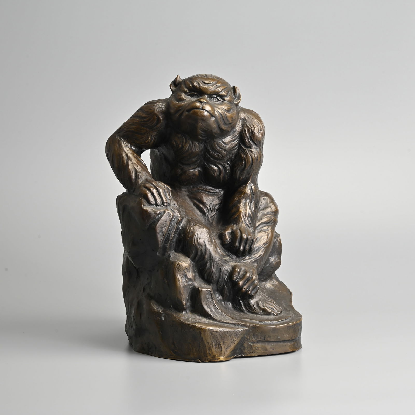 JAPANESE BRONZE MODEL OF A MONKEY BY WATANABE KANSUI (1929), 20TH CENTURY.: JAPANESE BRONZE MODEL OF A MONKEY BY WATANABE KANSUI (1929), 20TH CENTURY. Naturalistically modelled seated on rockwork, signed with two characters to base, with foundry seal to reverse of rockwork, 3