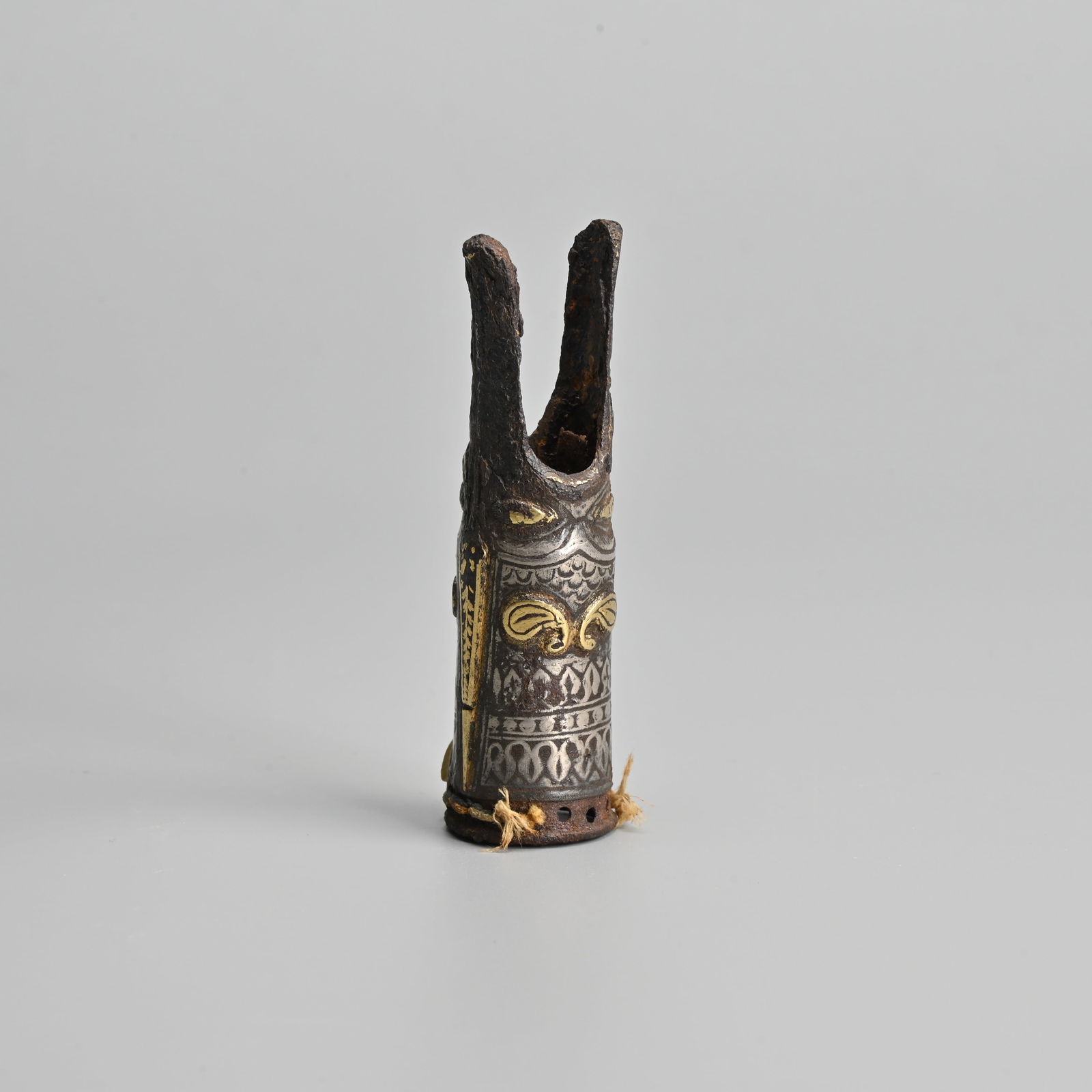 AN ISLAMIC DAMASCUS IRON FITTING, 19TH CENTURY OR EARLIER.: AN ISLAMIC DAMASCUS IRON FITTING, 19TH CENTURY OR EARLIER. Hollowed cylindrical section with two protruding ends, inlaid decorated in white and yellow metal. Pierced holes to the other end. 8.5cm leng